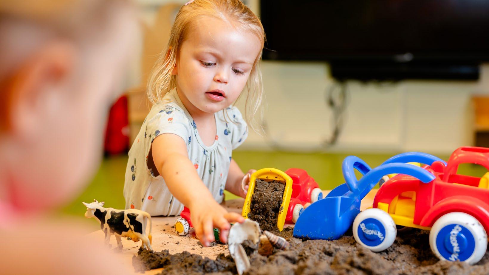 Kindcentrum De Morgenster in Zwolle, waar kinderen spelen met speelgoed in de zandbak.