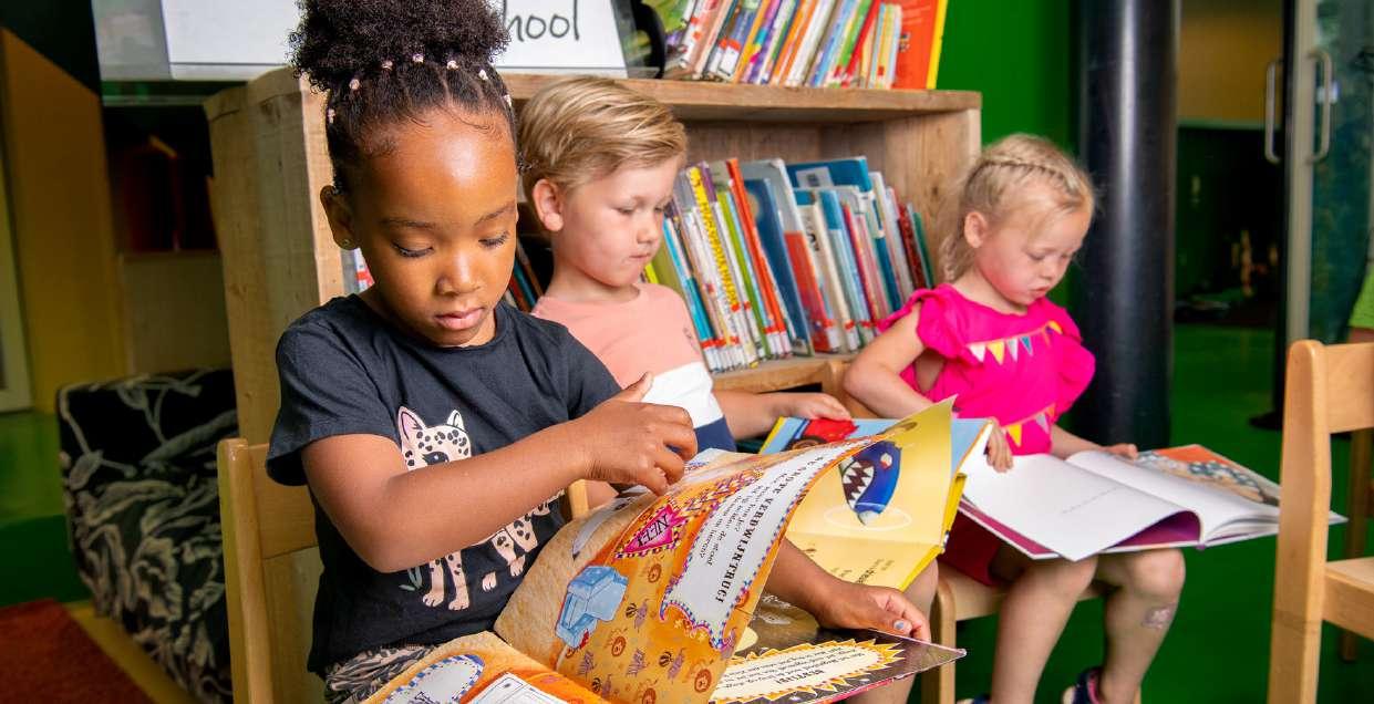 Kindcentrum De Spreng in Barneveld stimuleert lezen met kinderen die boeken bekijken in de boekenkamer. Kindcentrum De Spreng in Barneveld stimuleert lezen met kinderen die boeken bekijken in de boekenkamer.