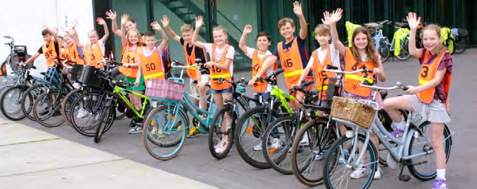 Kindcentrum Dierdonk in Helmond: kinderen in veiligheidshesjes met fietsen op het schoolplein. Kindcentrum Dierdonk in Helmond: kinderen in veiligheidshesjes met fietsen op het schoolplein.