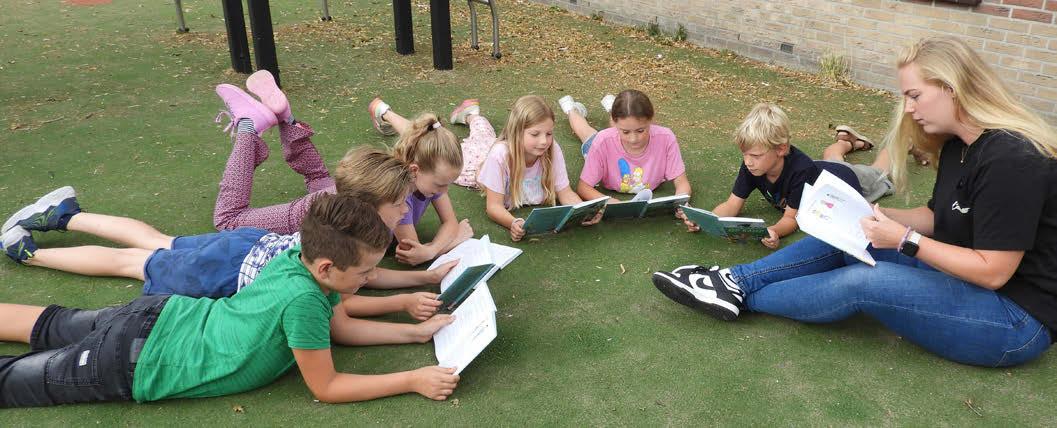 Kindcentrum Helmgras in Castricum: kinderen lezen samen op het schoolplein. Kindcentrum Helmgras in Castricum: kinderen lezen samen op het schoolplein.
