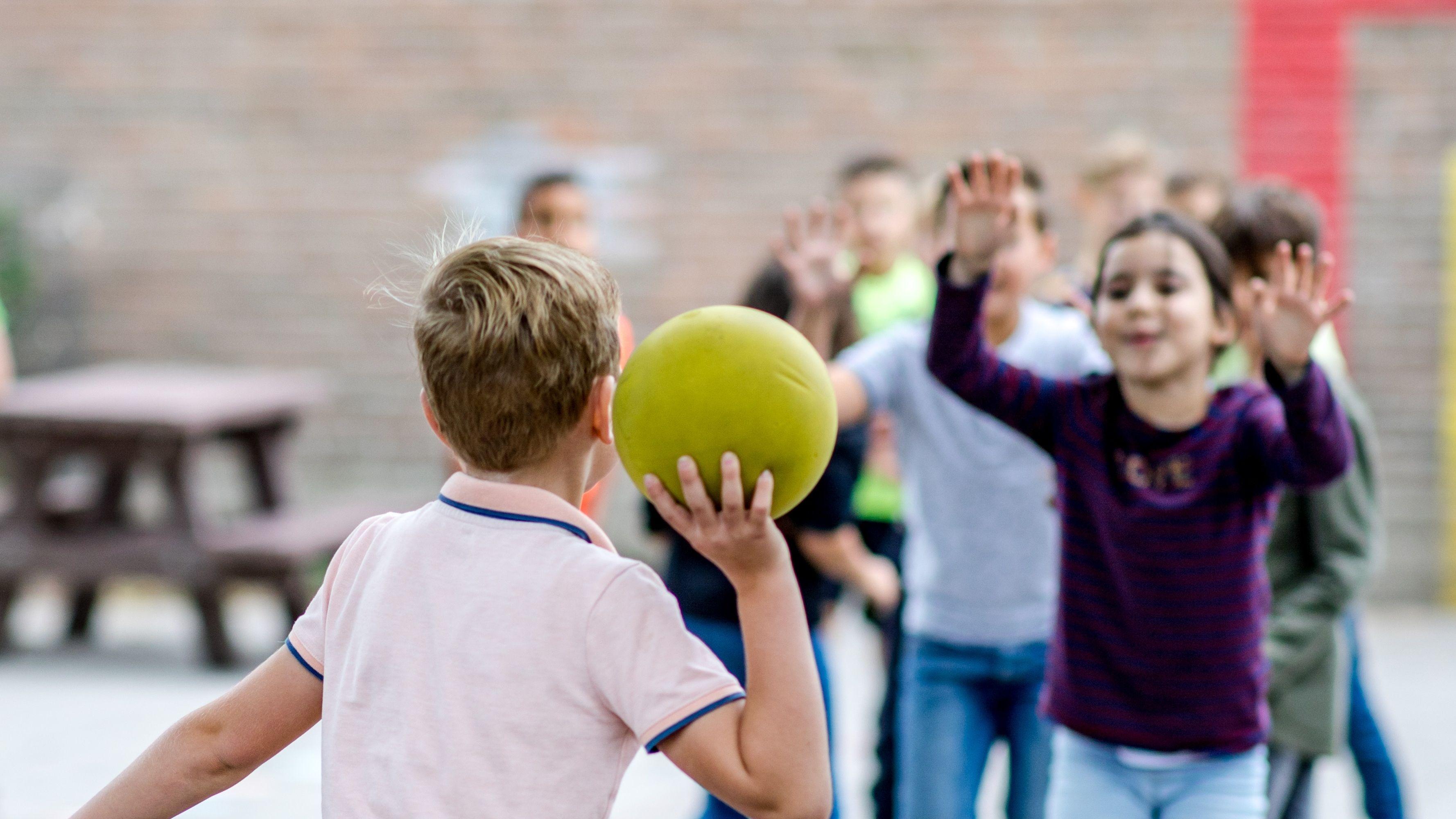 Kindcentrum Jij in Terheijden: Kinderen spelen met een groene bal op het schoolplein.