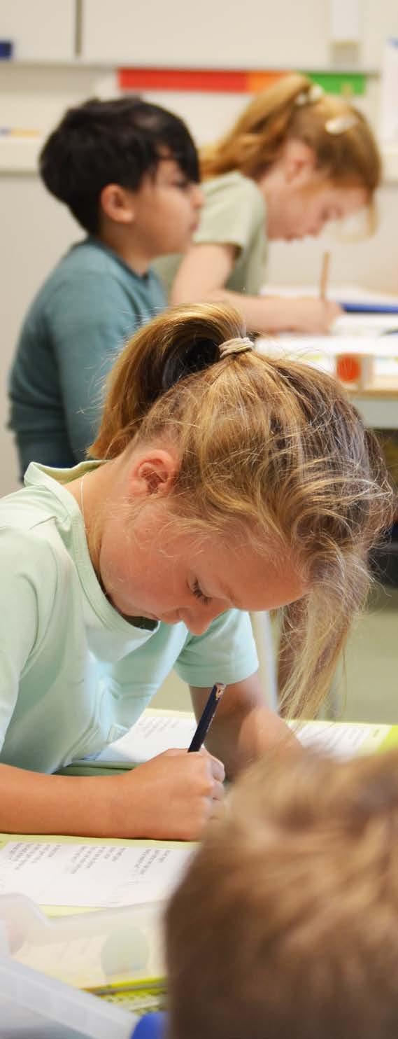 Kindcentrum Theresia in Eindhoven: leerlingen die geconcentreerd schrijven aan hun bureau. Kindcentrum Theresia in Eindhoven: leerlingen die geconcentreerd schrijven aan hun bureau.