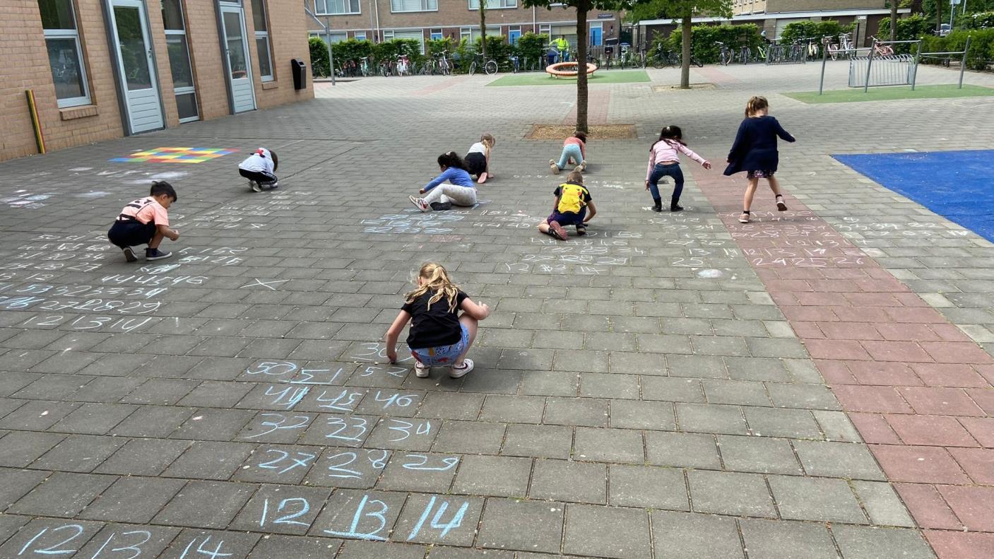 Kindcentrum Westerbreedte in Den Bosch, kinderen die met krijt op het schoolplein aan het rekenen zijn. Kindcentrum Westerbreedte in Den Bosch, kinderen die met krijt op het schoolplein aan het rekenen zijn.