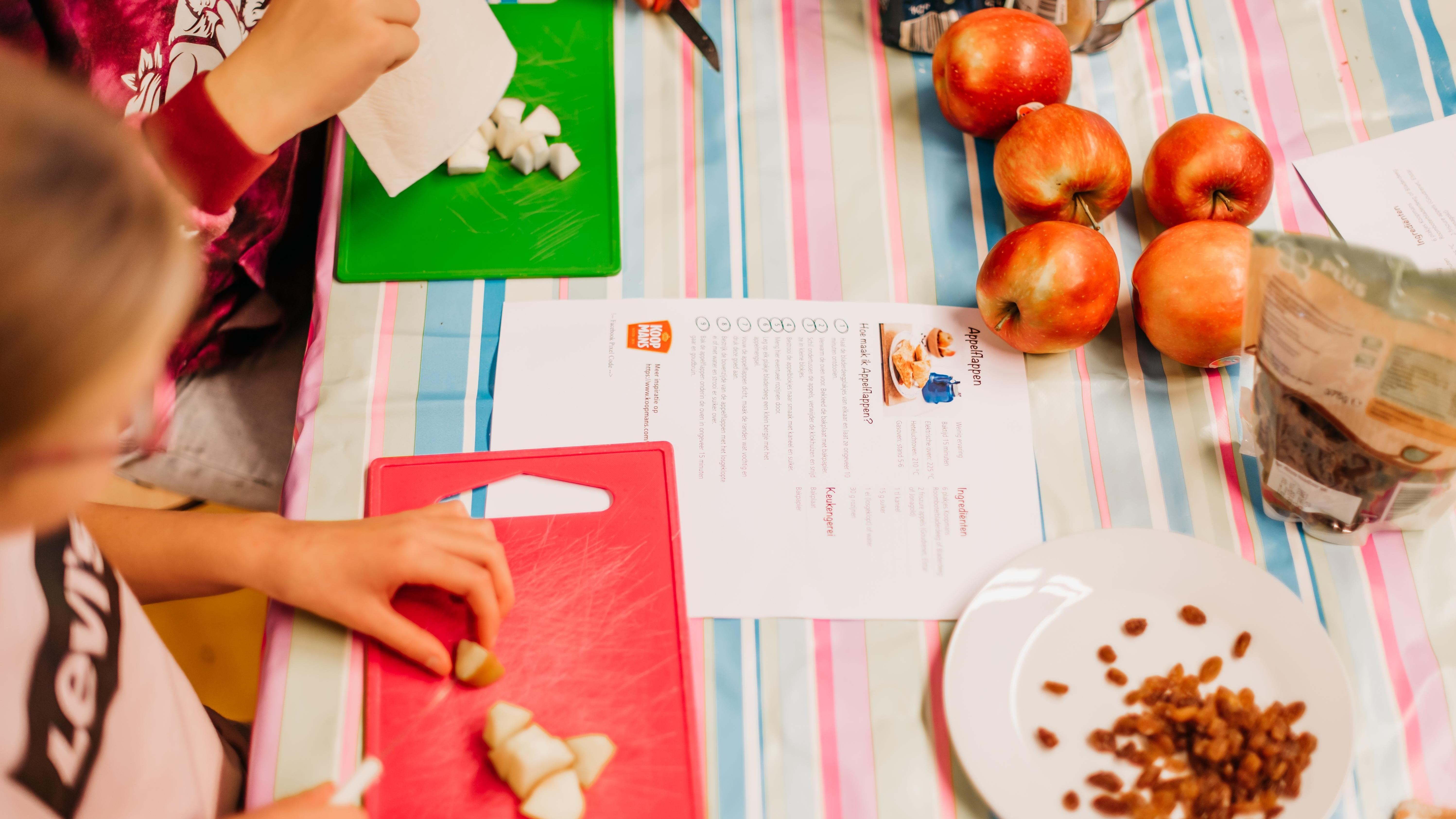 Kinderen aan Basisschool Stokkum in Markelo bereiden gezonde appelrepen met verse ingrediënten op een kleurrijke tafel. Kinderen aan Basisschool Stokkum in Markelo bereiden gezonde appelrepen met verse ingrediënten op een kleurrijke tafel.