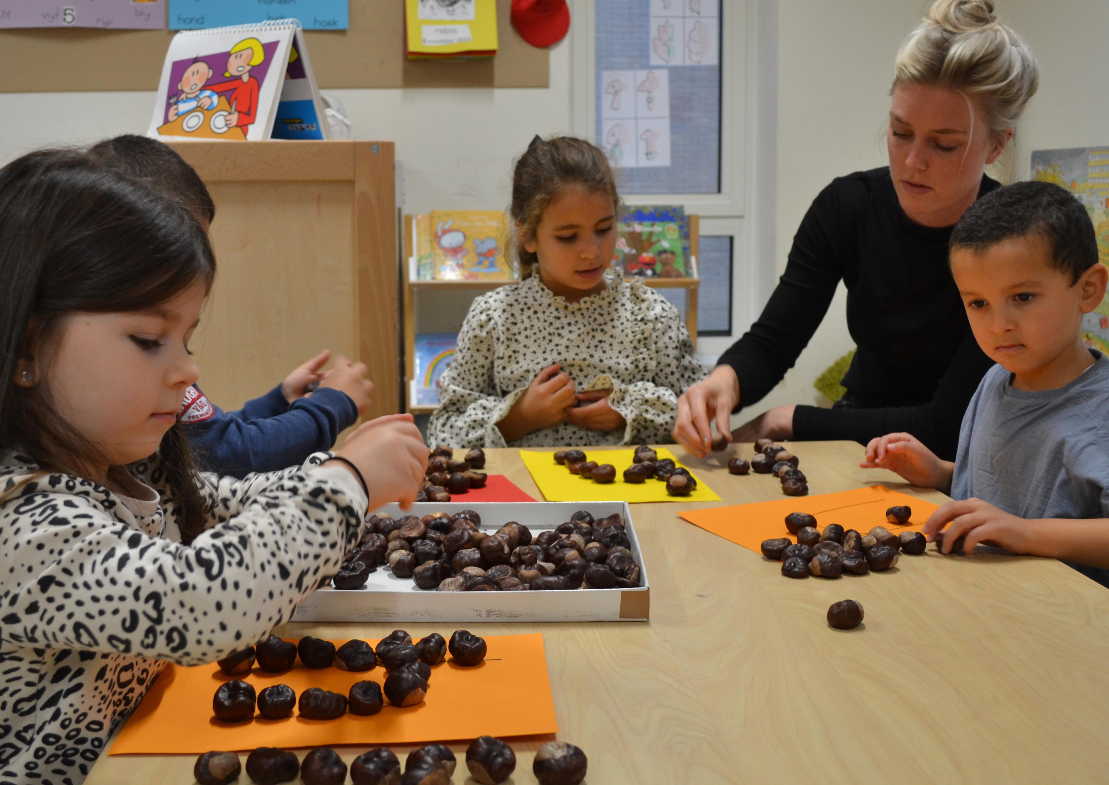 Kinderen aan de Burgemeester De Vlugtschool in Amsterdam zijn bezig met een creatief project met kastanjes. Kinderen aan de Burgemeester De Vlugtschool in Amsterdam zijn bezig met een creatief project met kastanjes.