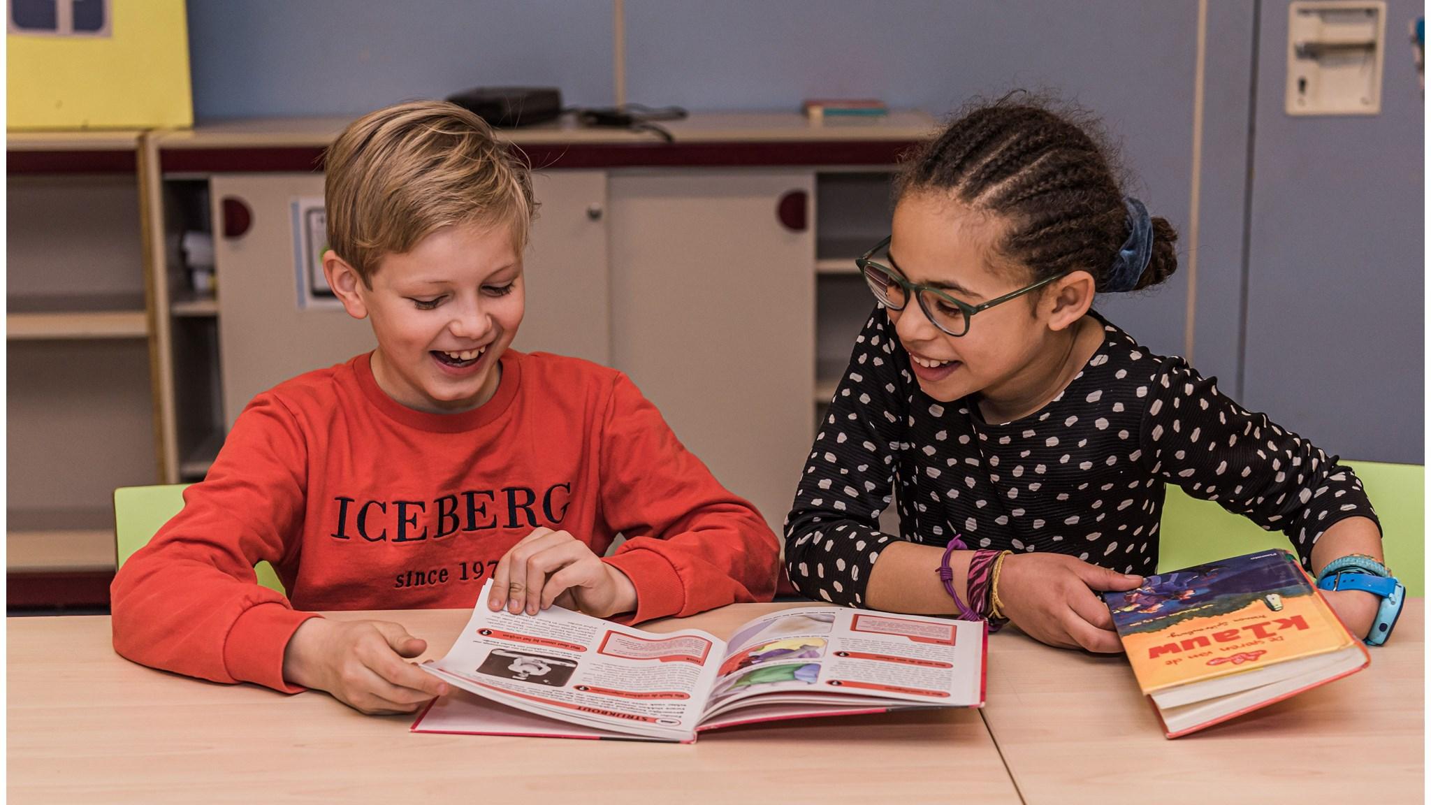 Kinderen aan Oecumenische Basisschool De Binnendijk in Monnickendam lezen en lachen samen in de klas. Kinderen aan Oecumenische Basisschool De Binnendijk in Monnickendam lezen en lachen samen in de klas.