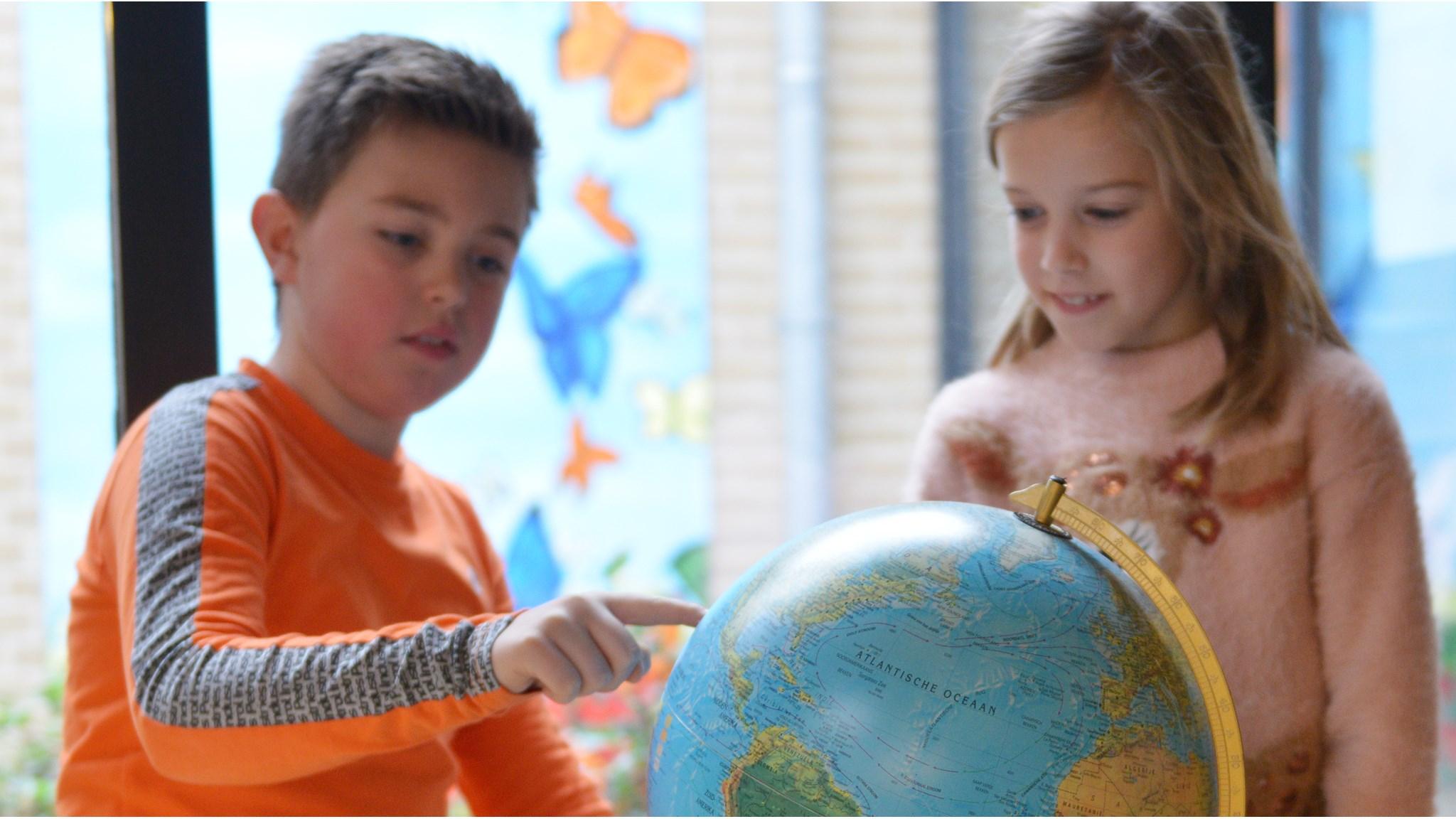 Kinderen die een globe bestuderen in de Mariaschool in Reutum. Kinderen die een globe bestuderen in de Mariaschool in Reutum.