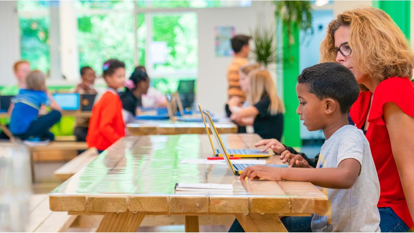 Kinderen en een docent werken samen aan laptops in de Katholieke Basisschool Het Kofschip in Ouderkerk aan de Amstel. Kinderen en een docent werken samen aan laptops in de Katholieke Basisschool Het Kofschip in Ouderkerk aan de Amstel.