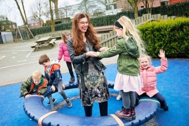 Kinderen en een docente spelen op het schoolplein van Basisschool De Bron in Sprang-Capelle. Kinderen en een docente spelen op het schoolplein van Basisschool De Bron in Sprang-Capelle.