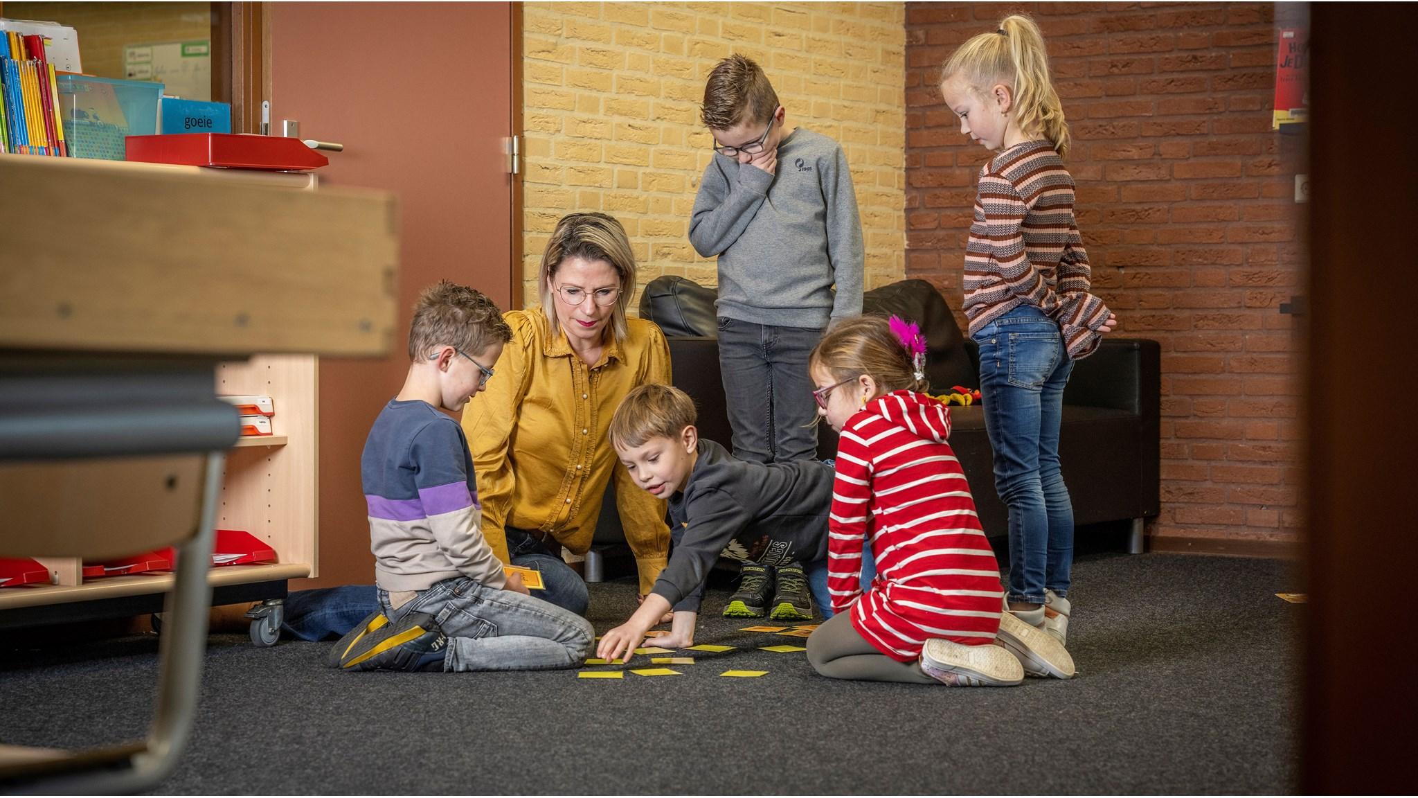 Kinderen en een leerkracht spelen een spel in het klaslokaal van KC LEEF in Kessel. Kinderen en een leerkracht spelen een spel in het klaslokaal van KC LEEF in Kessel.