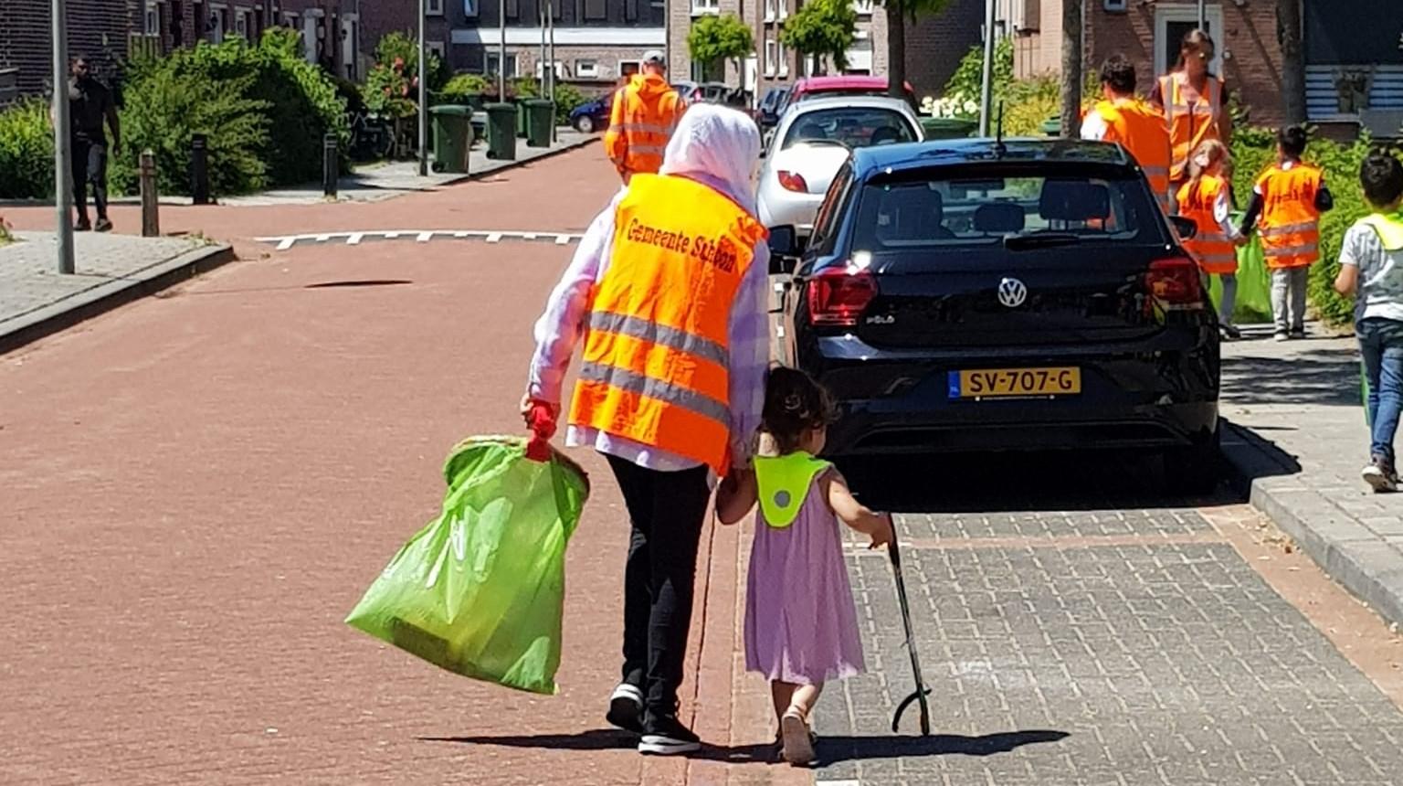 Kinderen en vrijwilligers van basisschool De Zonnewijzer in Roermond halen zwerfafval op in de buurt. Kinderen en vrijwilligers van basisschool De Zonnewijzer in Roermond halen zwerfafval op in de buurt.