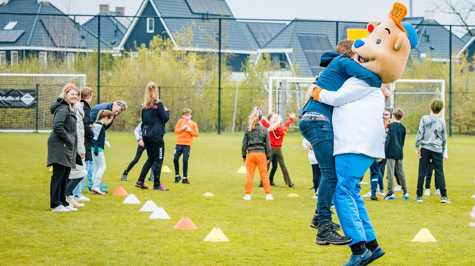 Kinderen genieten van activiteiten op het schoolplein van De Wheemschool in Voorthuizen, met een mascotte die meedoet. Kinderen genieten van activiteiten op het schoolplein van De Wheemschool in Voorthuizen, met een mascotte die meedoet.