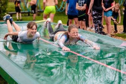 Kinderen genieten van een waterglijbaan op het schoolplein van de Antoniusschool in Kudelstaart. Kinderen genieten van een waterglijbaan op het schoolplein van de Antoniusschool in Kudelstaart.