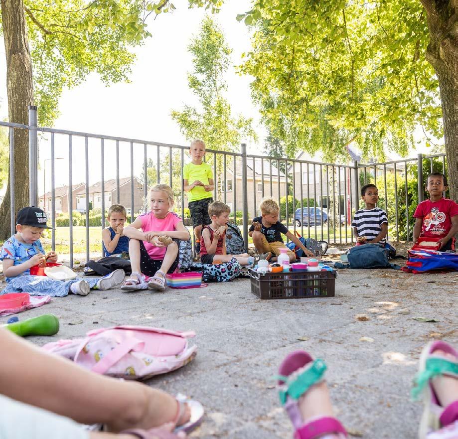 Kinderen genieten van hun lunch op het schoolplein van Christelijke Basisschool de Roerganger in Heerenveen. Kinderen genieten van hun lunch op het schoolplein van Christelijke Basisschool de Roerganger in Heerenveen.