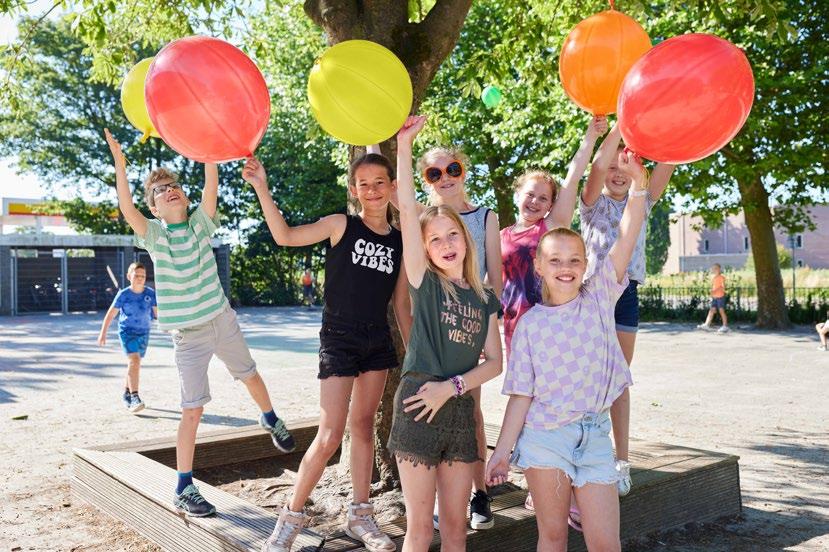 Kinderen hebben plezier op het schoolplein van Zwetteschool in Sneek met kleurrijke ballen. Kinderen hebben plezier op het schoolplein van Zwetteschool in Sneek met kleurrijke ballen.