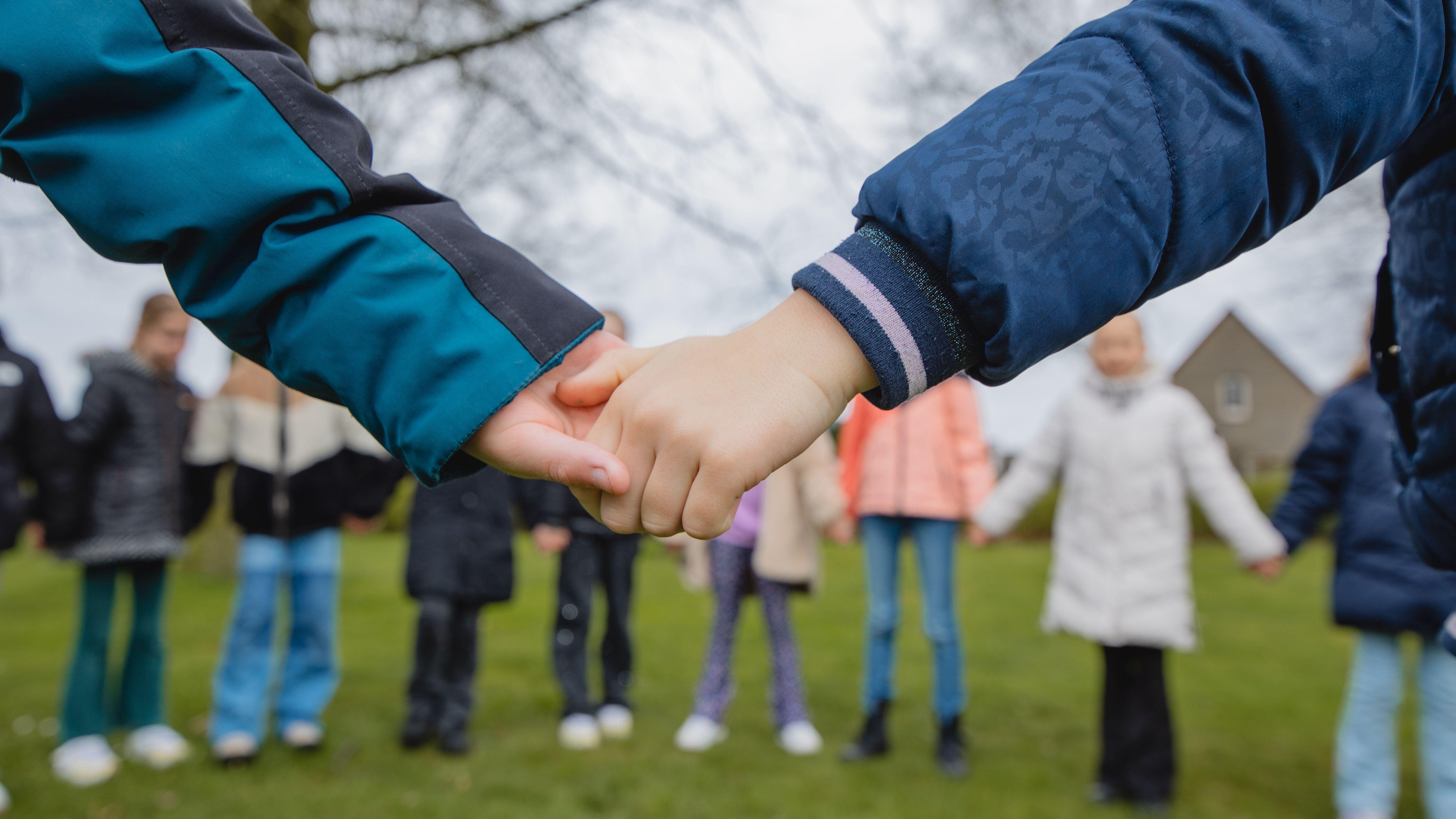 Kinderen houden handen vast op het schoolplein van Openbare Basisschool De Lisdodde in Emmen. Kinderen houden handen vast op het schoolplein van Openbare Basisschool De Lisdodde in Emmen.