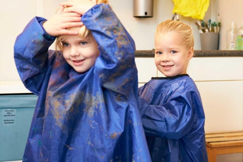 Kinderen in blauwe schorten spelen en leren bij de Koningsschool in Waalwijk. Kinderen in blauwe schorten spelen en leren bij de Koningsschool in Waalwijk.