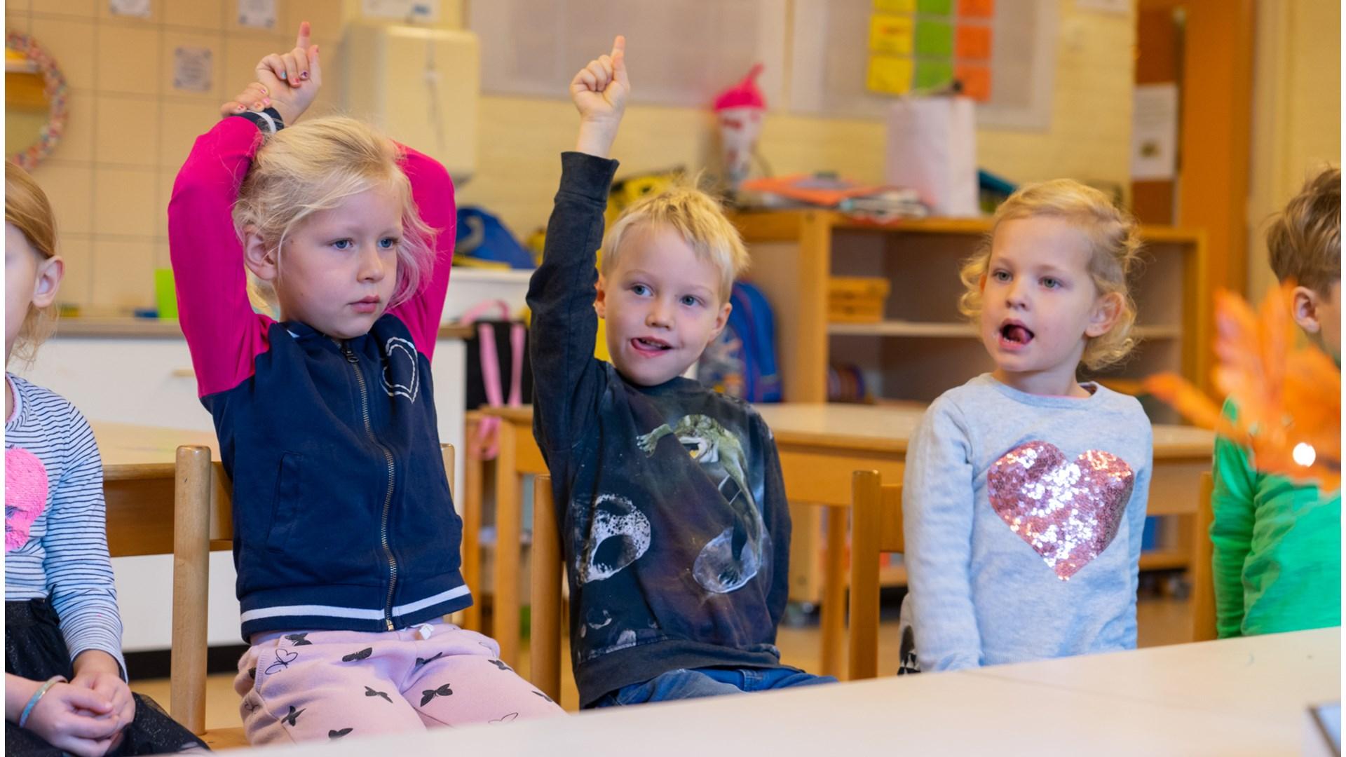Kinderen in de klas van De Zuidwester in Heiloo steken hun hand op.