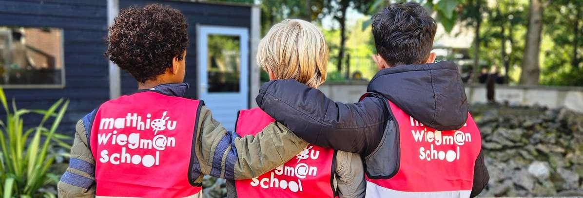 Kinderen in opvallende veiligheidsvesten van Basisschool M Wiegman staan samen op het schoolplein in Bergen (Noord-Holland). Kinderen in opvallende veiligheidsvesten van Basisschool M Wiegman staan samen op het schoolplein in Bergen (Noord-Holland).