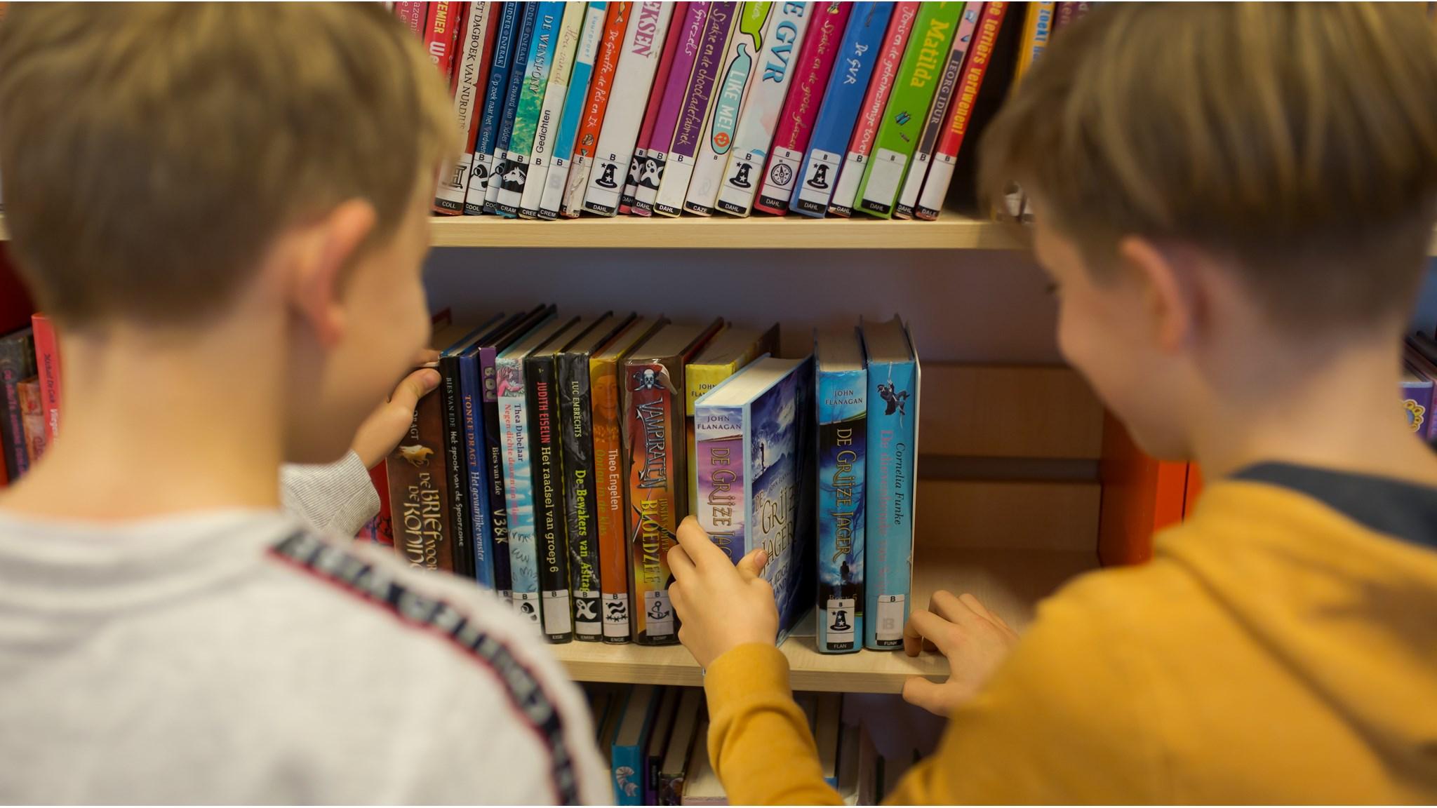 Kinderen kiezen boeken uit de boekenkast op CBS de Waterhof in Delft. Kinderen kiezen boeken uit de boekenkast op CBS de Waterhof in Delft.