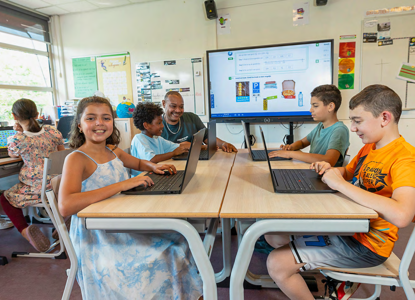 Kinderen leren met laptops in het klaslokaal van CBS Mozaïek in Rotterdam.