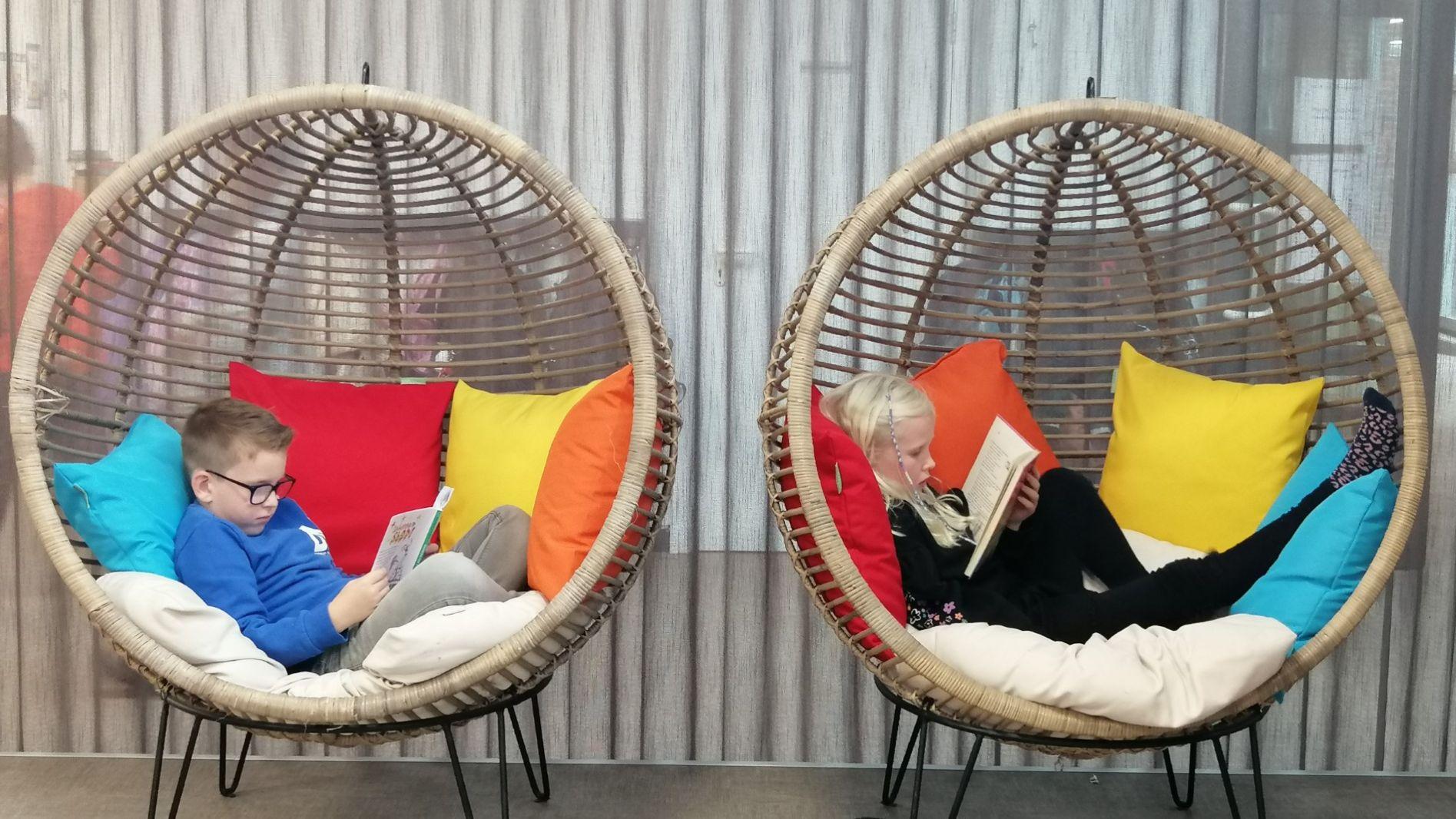 Kinderen lezen boeken in comfortabele hangstoelen op Basisschool d'n Heiakker in Deurne. Kinderen lezen boeken in comfortabele hangstoelen op Basisschool d'n Heiakker in Deurne.