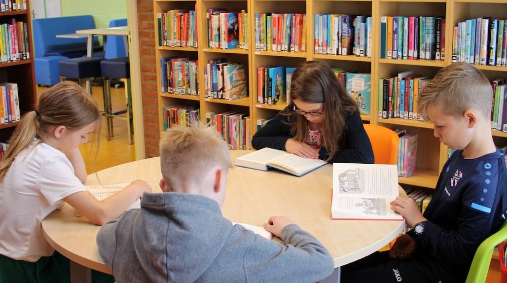 Kinderen lezen boeken in de bibliotheek van de Albertine Agnesschool in Oranjewoud.