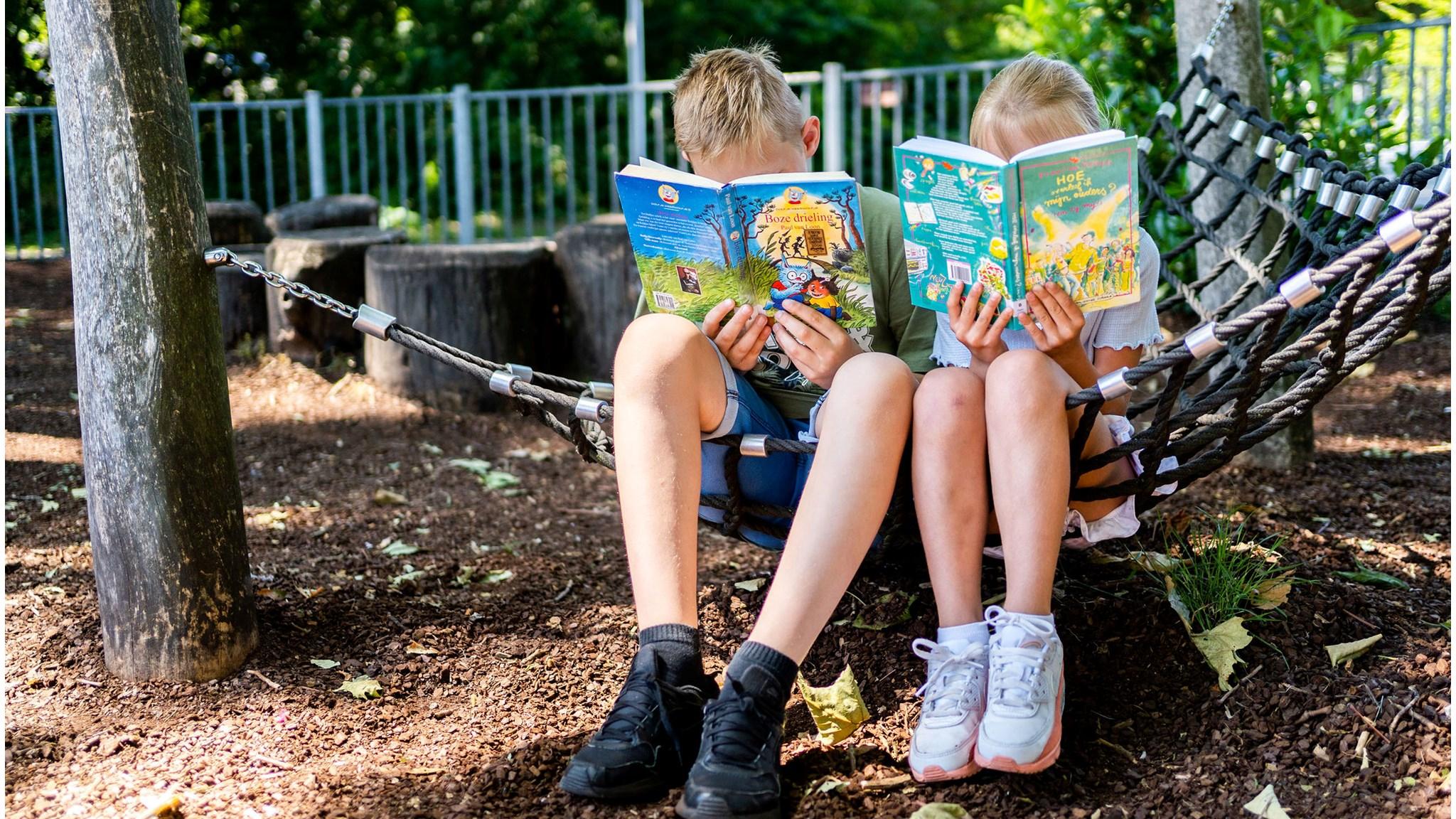 Kinderen lezen boeken in de hangmat op het schoolplein van de Johannesschool in Pijnacker. Kinderen lezen boeken in de hangmat op het schoolplein van de Johannesschool in Pijnacker.