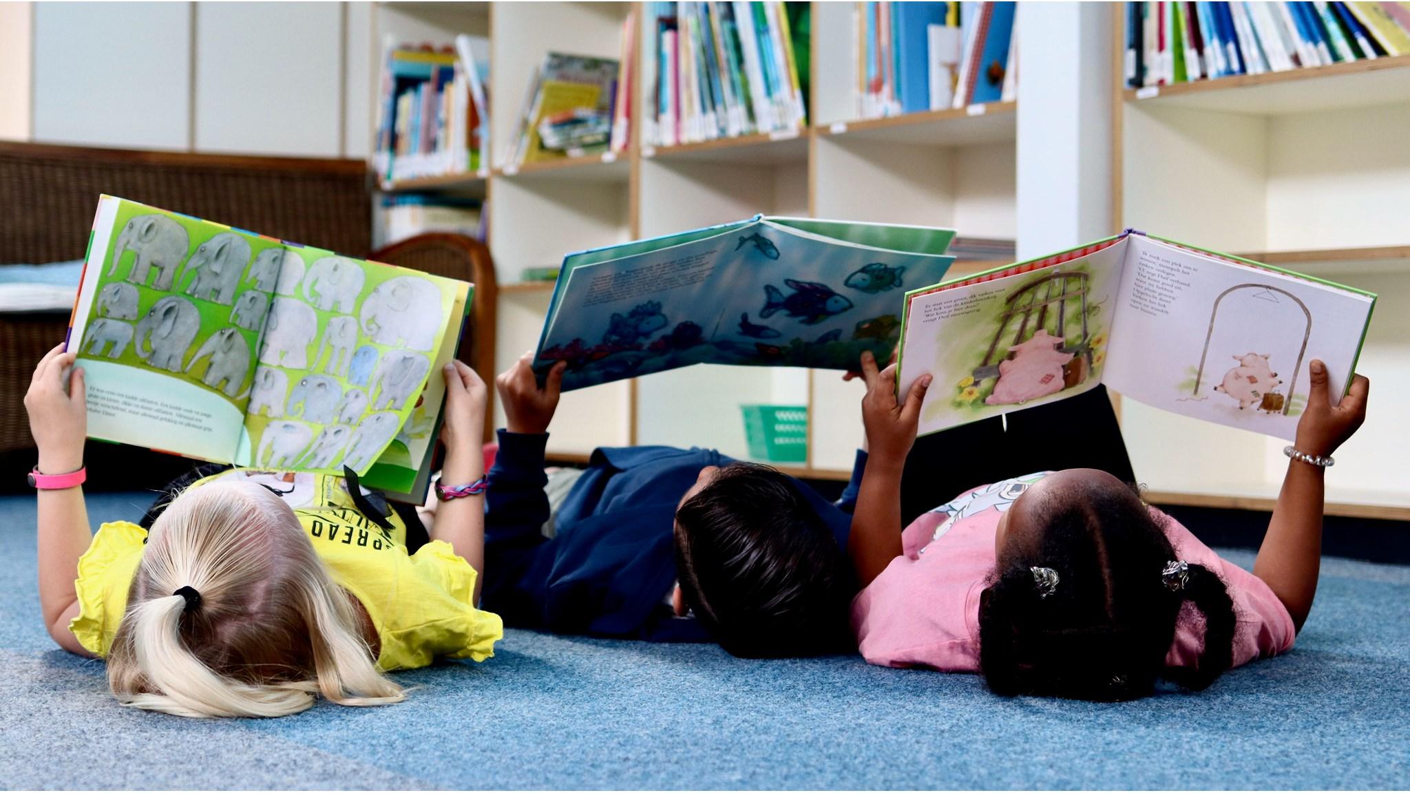 Kinderen lezen boeken op de vloer in de bibliotheek van KBS De Kameleon in Maarssen. Kinderen lezen boeken op de vloer in de bibliotheek van KBS De Kameleon in Maarssen.
