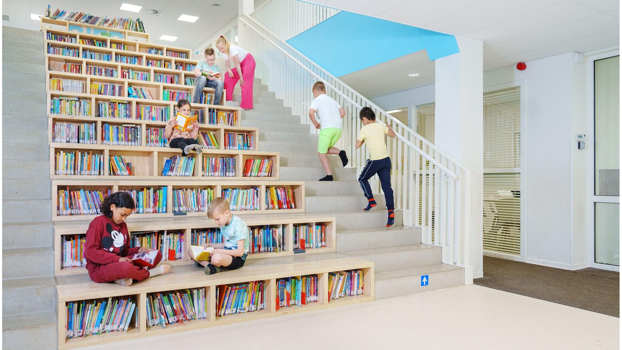 Kinderen lezen en spelen op de trappen van de bibliotheek in PCBO De Ploeg in Apeldoorn. Kinderen lezen en spelen op de trappen van de bibliotheek in PCBO De Ploeg in Apeldoorn.