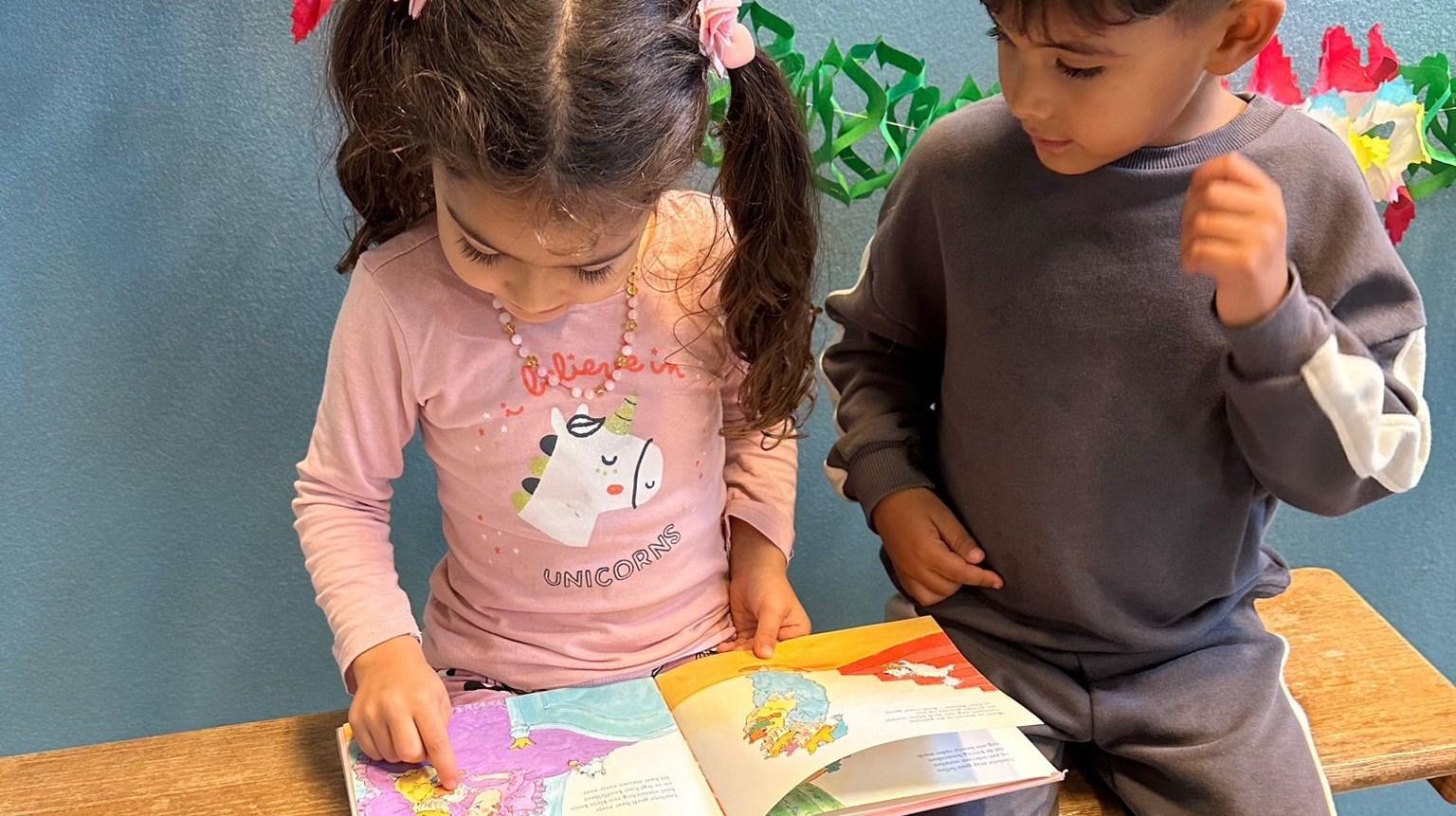 Kinderen lezen samen in een boek op Al Ummah in Enschede.