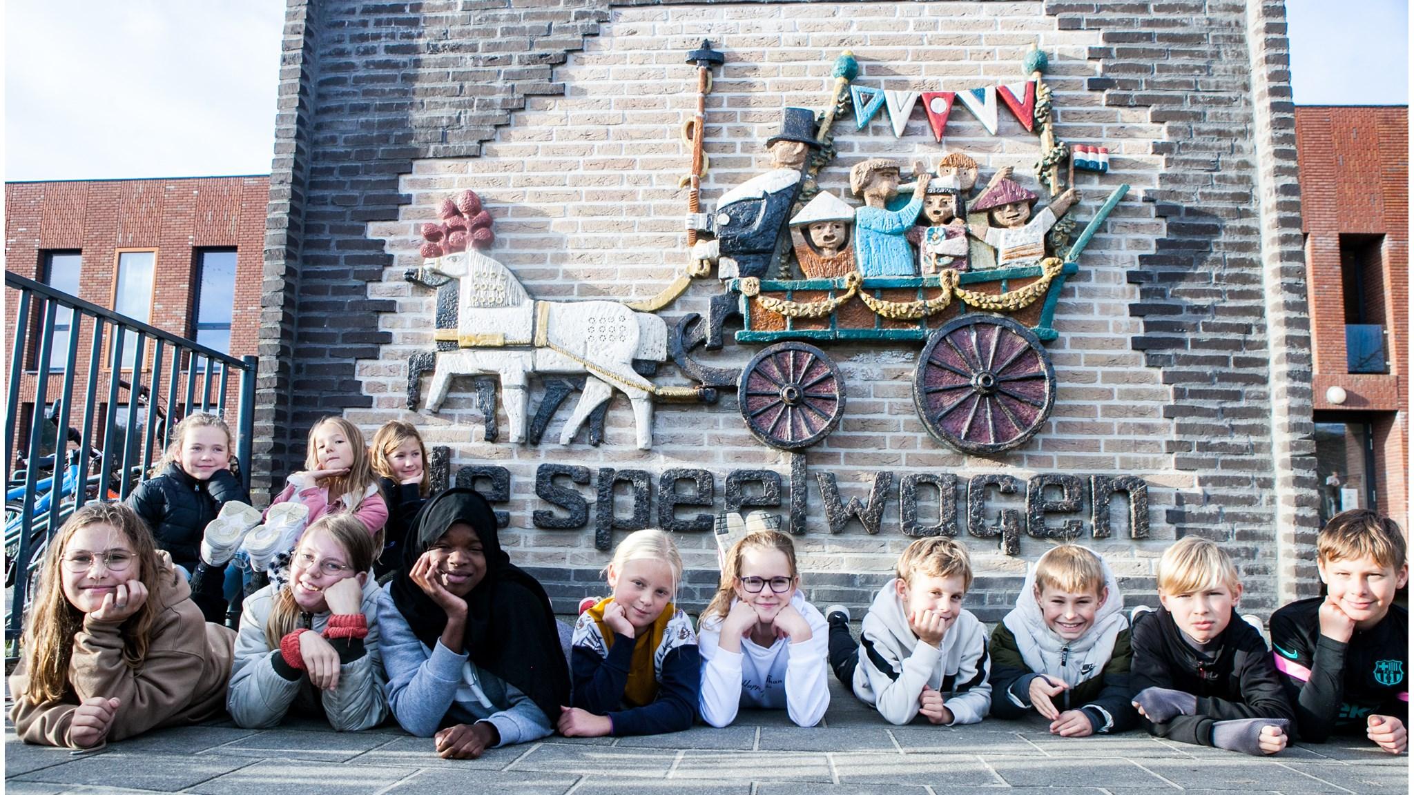 Kinderen liggen op het schoolplein van Basisschool de Speelwagen in Wognum. Kinderen liggen op het schoolplein van Basisschool de Speelwagen in Wognum.