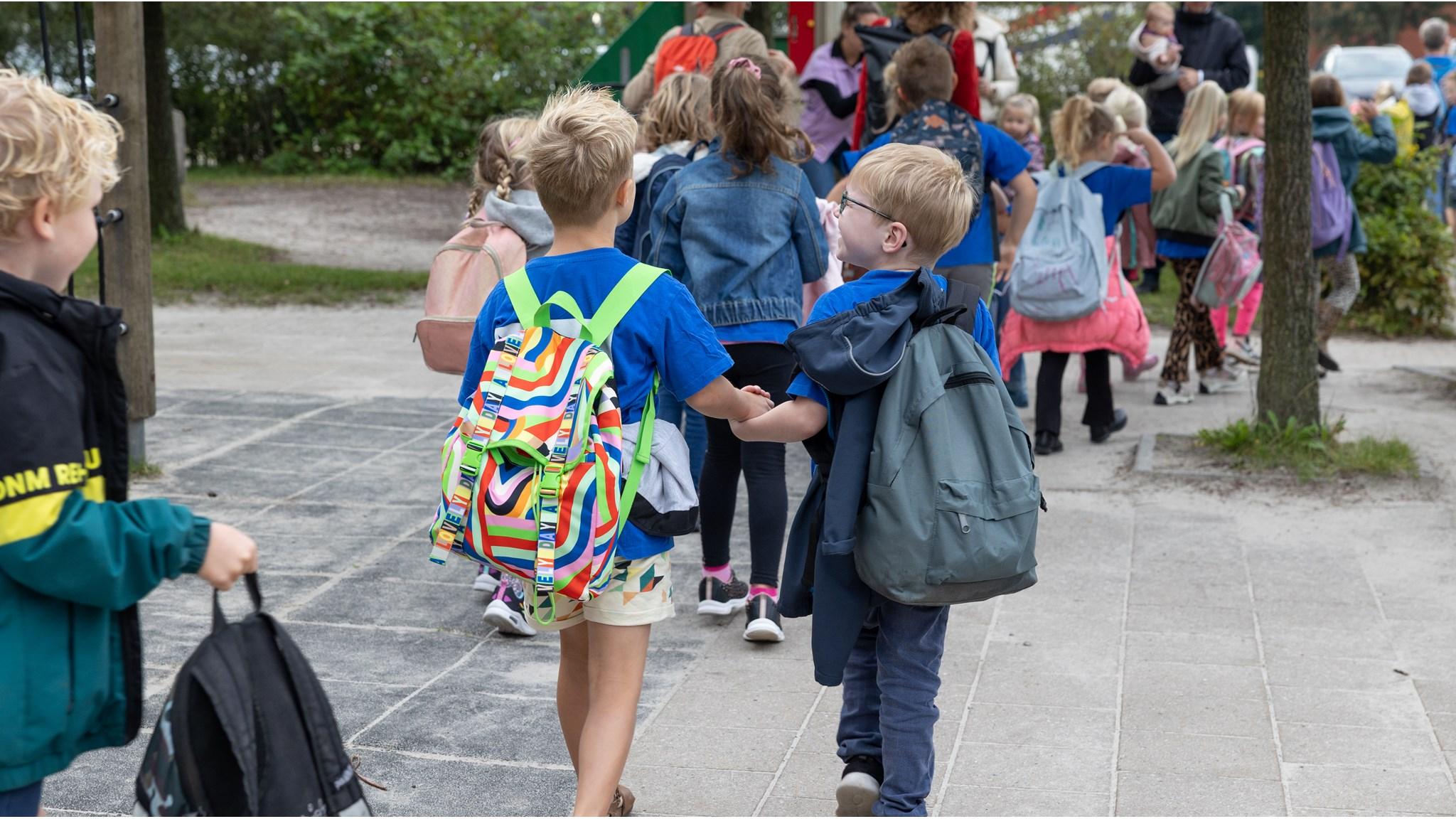 Kinderen lopen hand in hand naar het schoolplein van Openbare Basisschool De Twa Fisken in Grou. Kinderen lopen hand in hand naar het schoolplein van Openbare Basisschool De Twa Fisken in Grou.