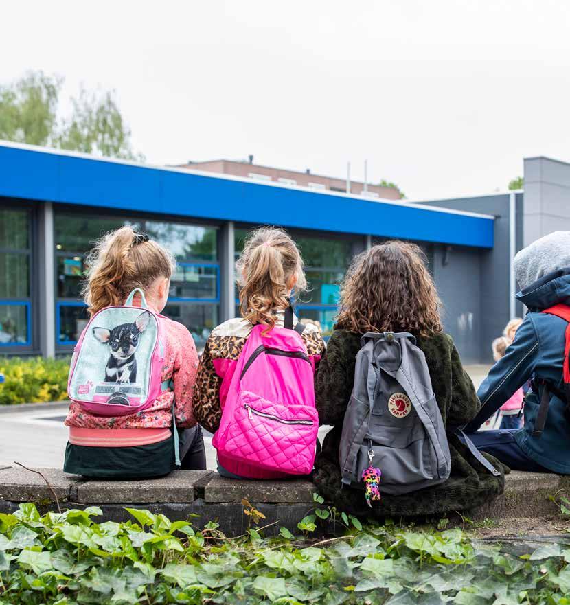 Kinderen met backpacks zitten op de rand van het schoolplein van Het Baken II in Veenendaal. Kinderen met backpacks zitten op de rand van het schoolplein van Het Baken II in Veenendaal.