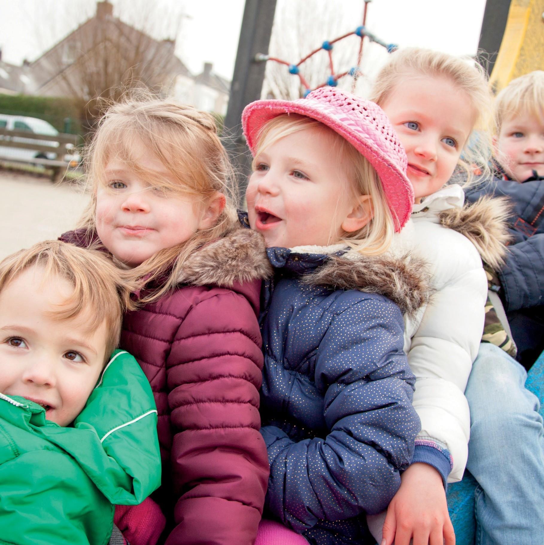 Kinderen met kleurrijke jassen en hoeden spelen samen op het schoolplein van Jenaplanschool De Waterval in Lisse. Kinderen met kleurrijke jassen en hoeden spelen samen op het schoolplein van Jenaplanschool De Waterval in Lisse.