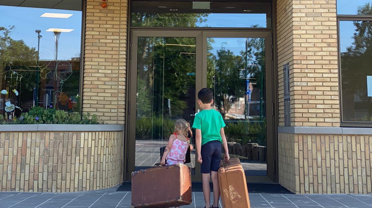 Kinderen met koffers voor de ingang van WereldKidz Achtbaan in Veenendaal. Kinderen met koffers voor de ingang van WereldKidz Achtbaan in Veenendaal.