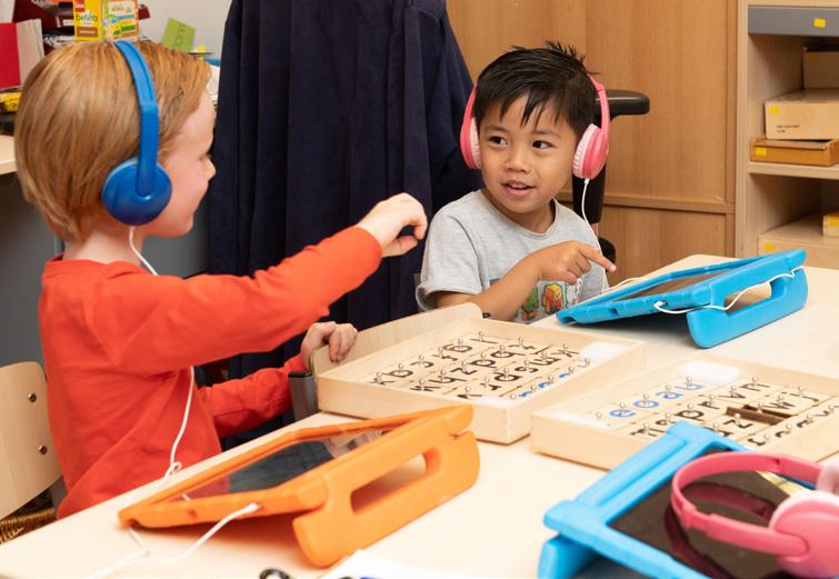 Kinderen met koptelefoons spelen met leermaterialen in het klaslokaal van De Kleine Keizer in Den Haag. Kinderen met koptelefoons spelen met leermaterialen in het klaslokaal van De Kleine Keizer in Den Haag.