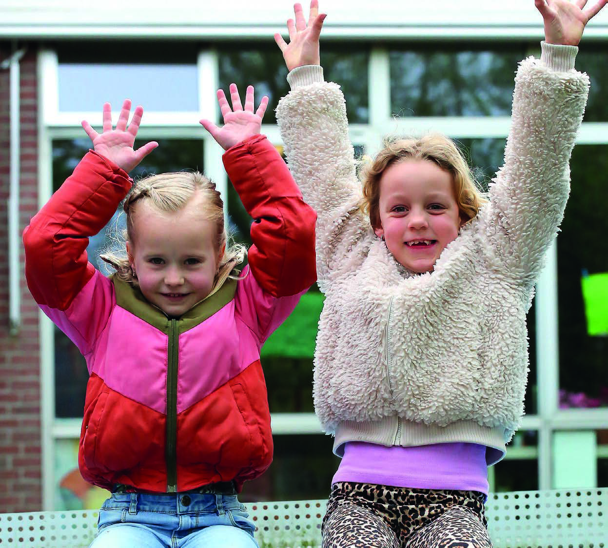 Kinderen met opgeheven handen op het schoolplein van Christelijk Kindcentrum De Wiedewereld in Sint Jansklooster. Kinderen met opgeheven handen op het schoolplein van Christelijk Kindcentrum De Wiedewereld in Sint Jansklooster.