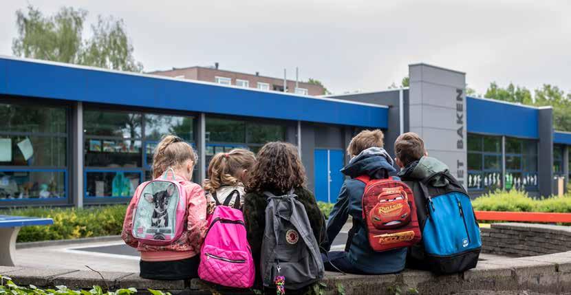 Kinderen met rugzakken ontspannen op de muur van het schoolplein van Het Baken I in Veenendaal. Kinderen met rugzakken ontspannen op de muur van het schoolplein van Het Baken I in Veenendaal.