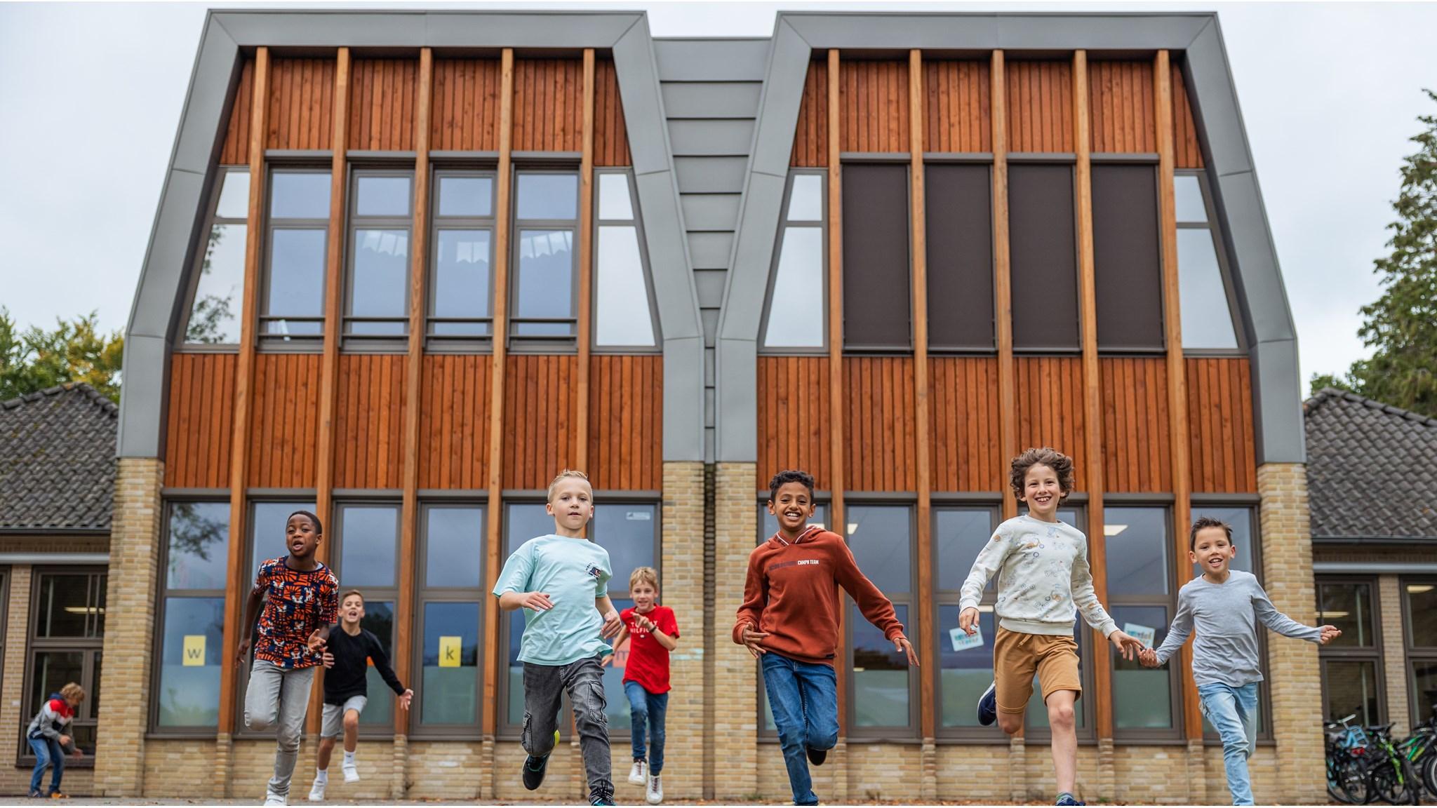 Kinderen rennen blij over het schoolplein van IKC-WereldWijs in Loosdrecht. Kinderen rennen blij over het schoolplein van IKC-WereldWijs in Loosdrecht.