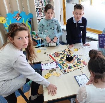 Kinderen spelen een bordspel in de klas van Stichting voor basisonderwijs op GG in Sint Philipsland.