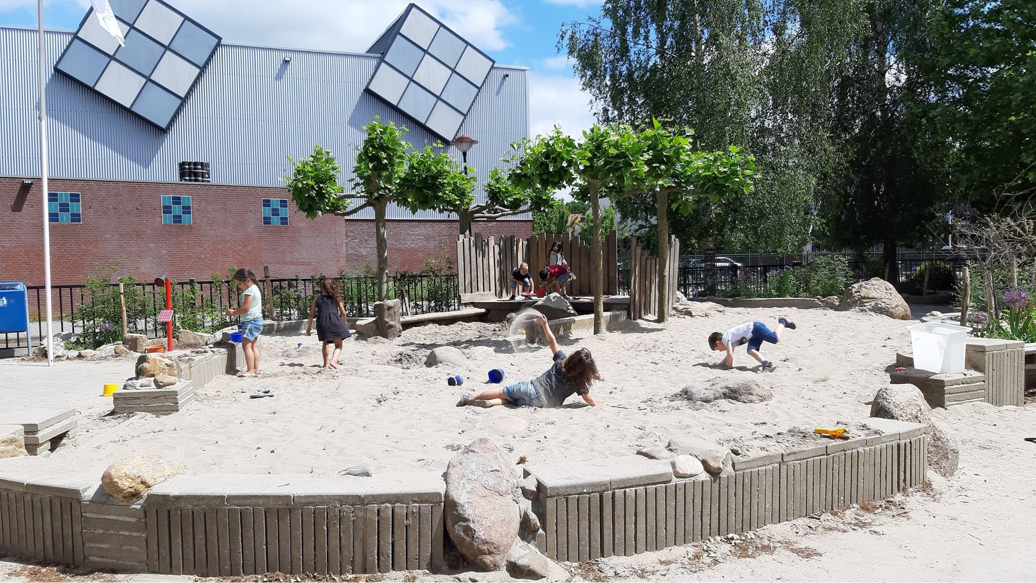 Kinderen spelen in het zand op het schoolplein van Montessori Basisschool De Kosmos in Hoogland. Kinderen spelen in het zand op het schoolplein van Montessori Basisschool De Kosmos in Hoogland.