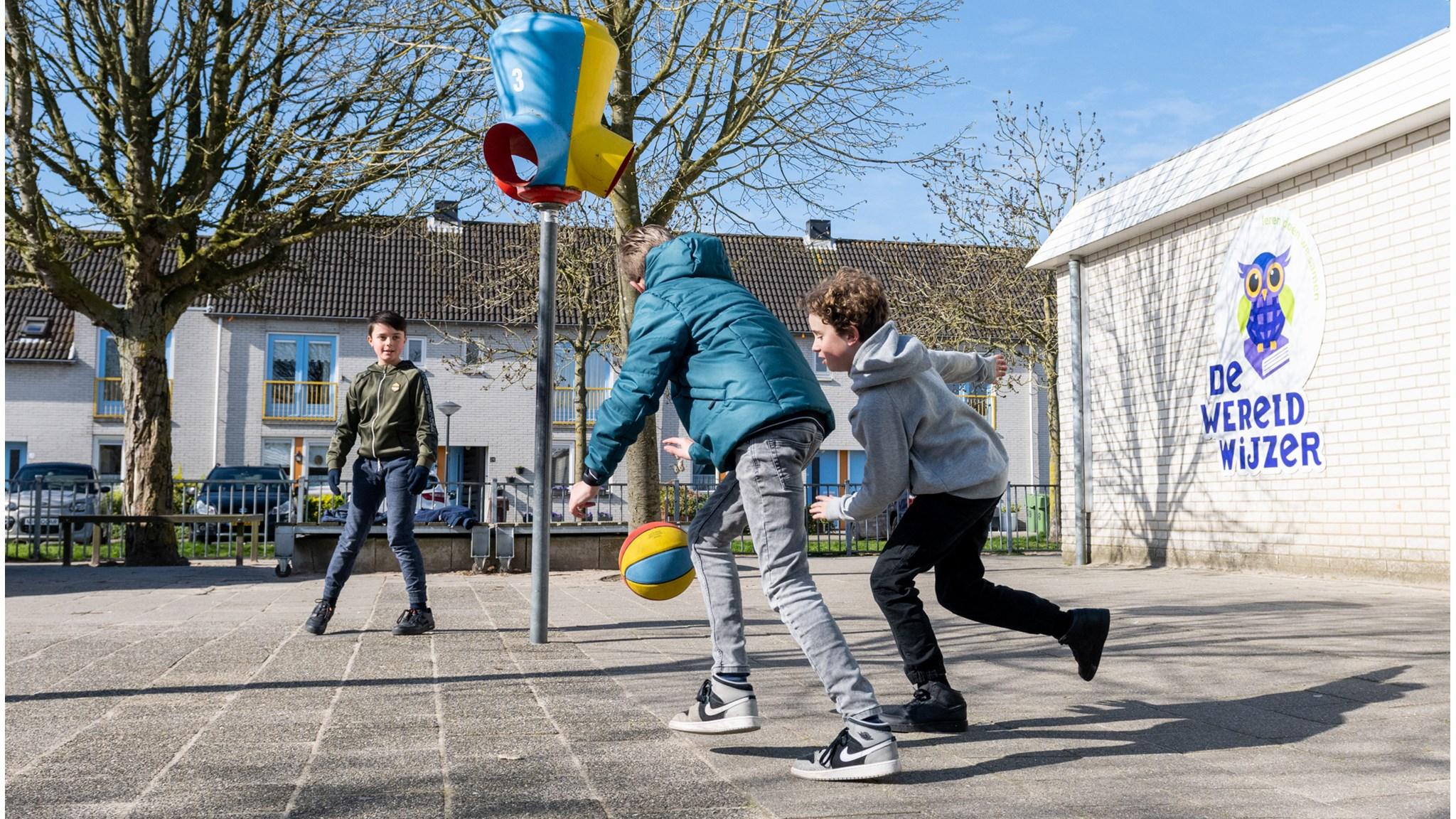 Kinderen spelen met een basketbal op het schoolplein van Basisschool De Wereldwijzer in Leiden. Kinderen spelen met een basketbal op het schoolplein van Basisschool De Wereldwijzer in Leiden.