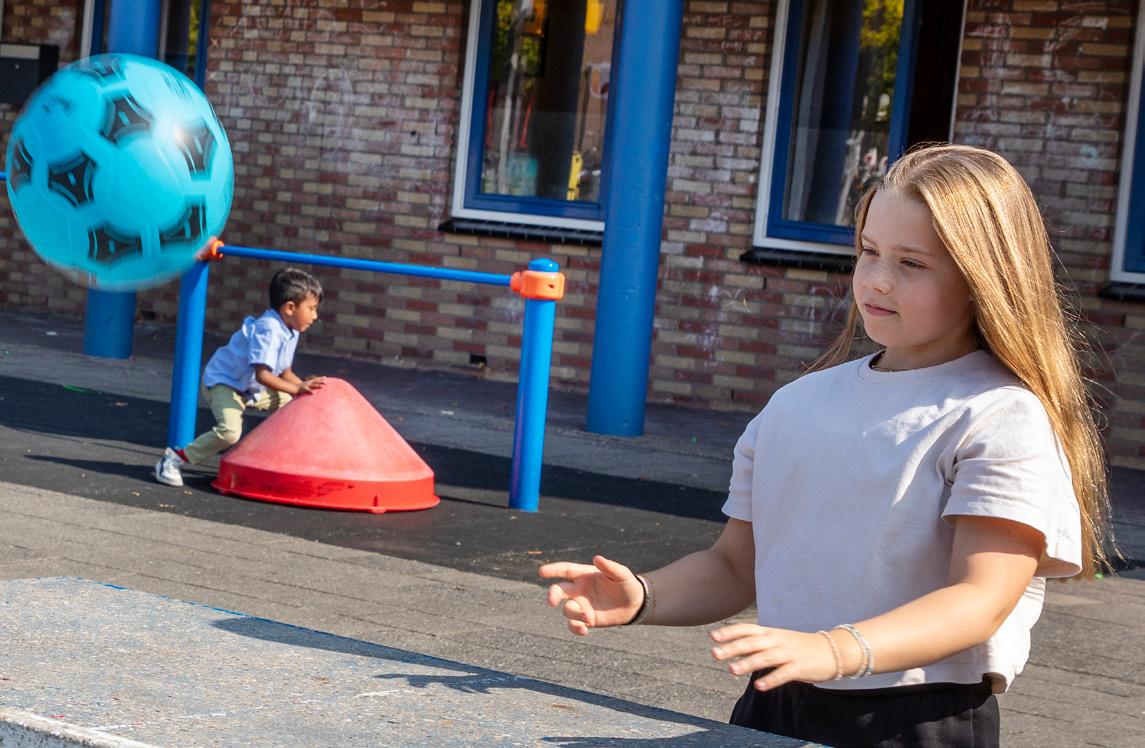 Kinderen spelen met een grote blauwe bal op het schoolplein van De Wereldwijzer in Alphen aan den Rijn. Kinderen spelen met een grote blauwe bal op het schoolplein van De Wereldwijzer in Alphen aan den Rijn.