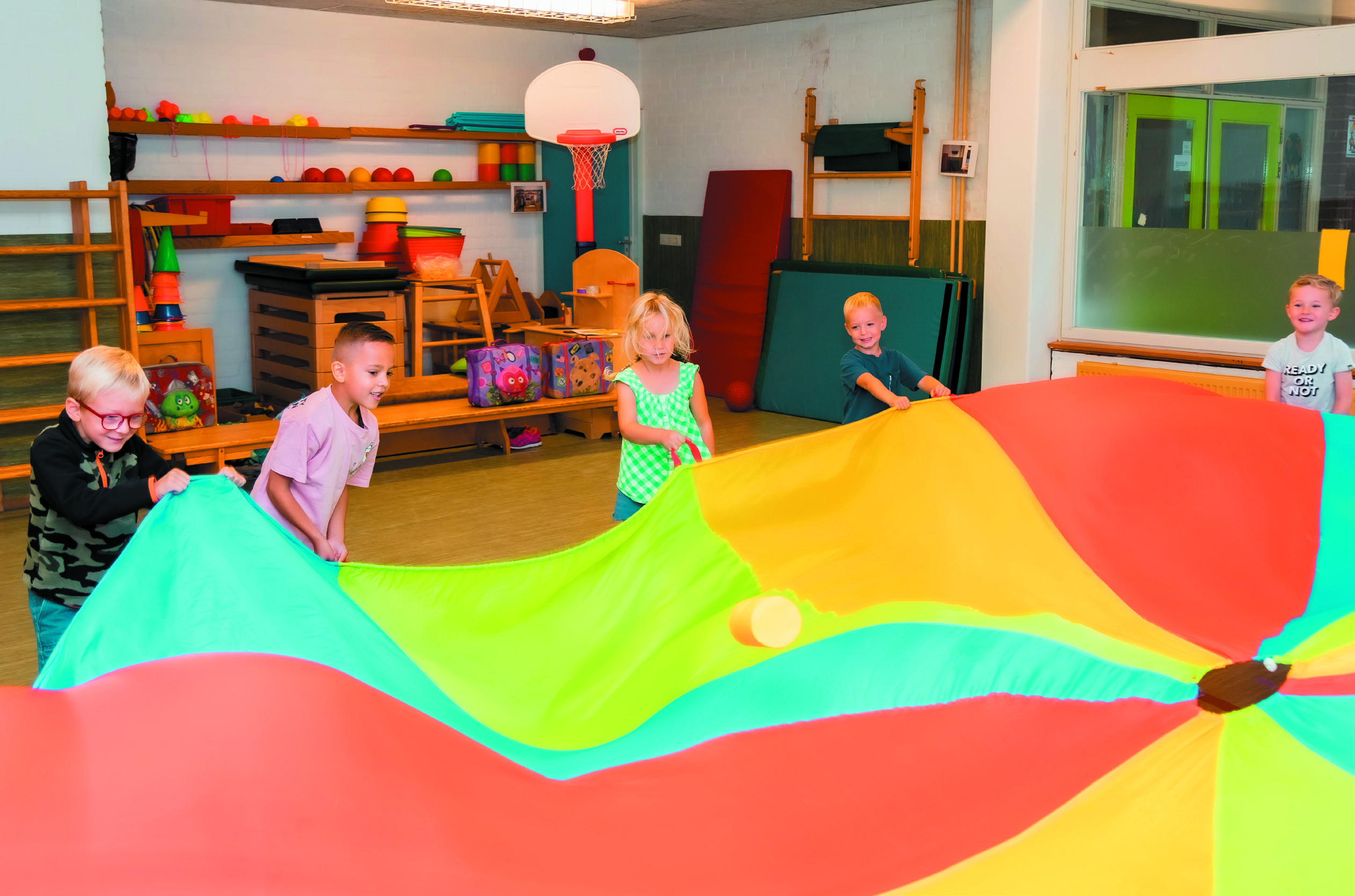 Kinderen spelen met een kleurrijk parachute in De Trompetvogel in Nieuwegein. Kinderen spelen met een kleurrijk parachute in De Trompetvogel in Nieuwegein.