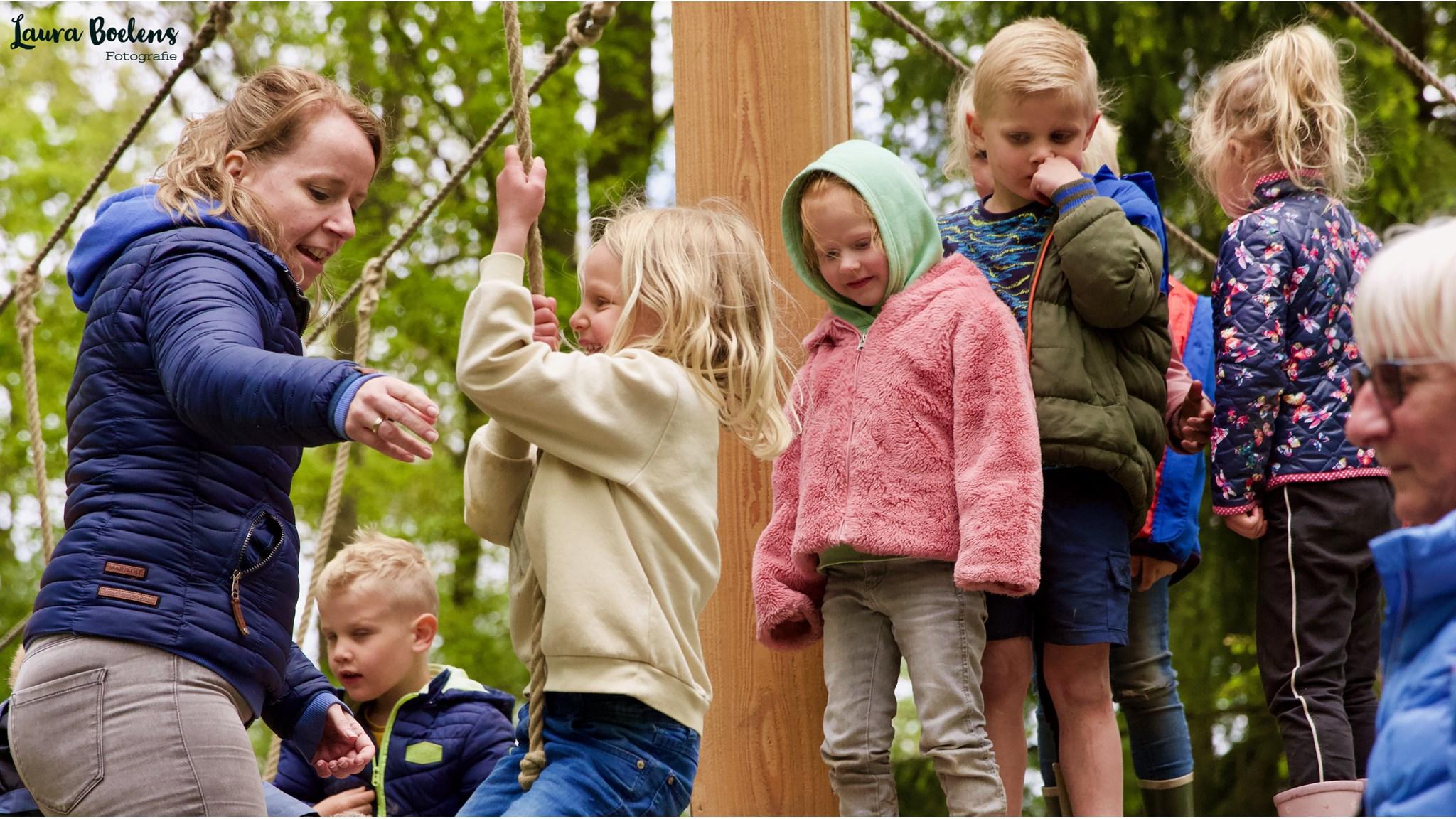 Kinderen spelen met een lerares op het schoolplein van de Tjongerschool in Mildam.