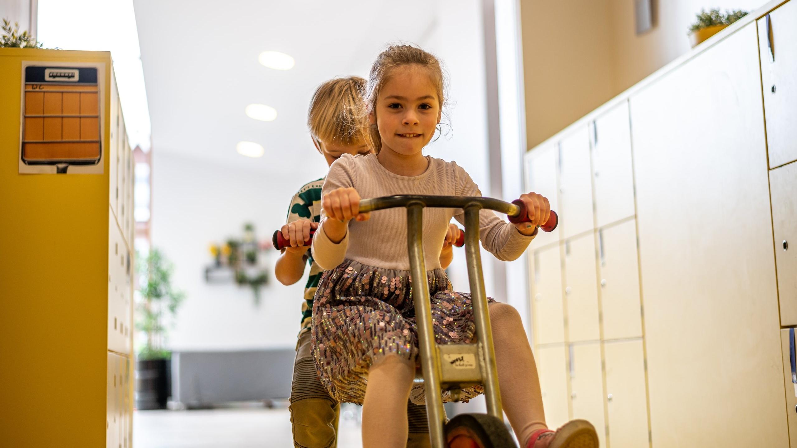 Kinderen spelen met een loopfiets in de gang van Basisschool De Regenboog in De Bilt. Kinderen spelen met een loopfiets in de gang van Basisschool De Regenboog in De Bilt.
