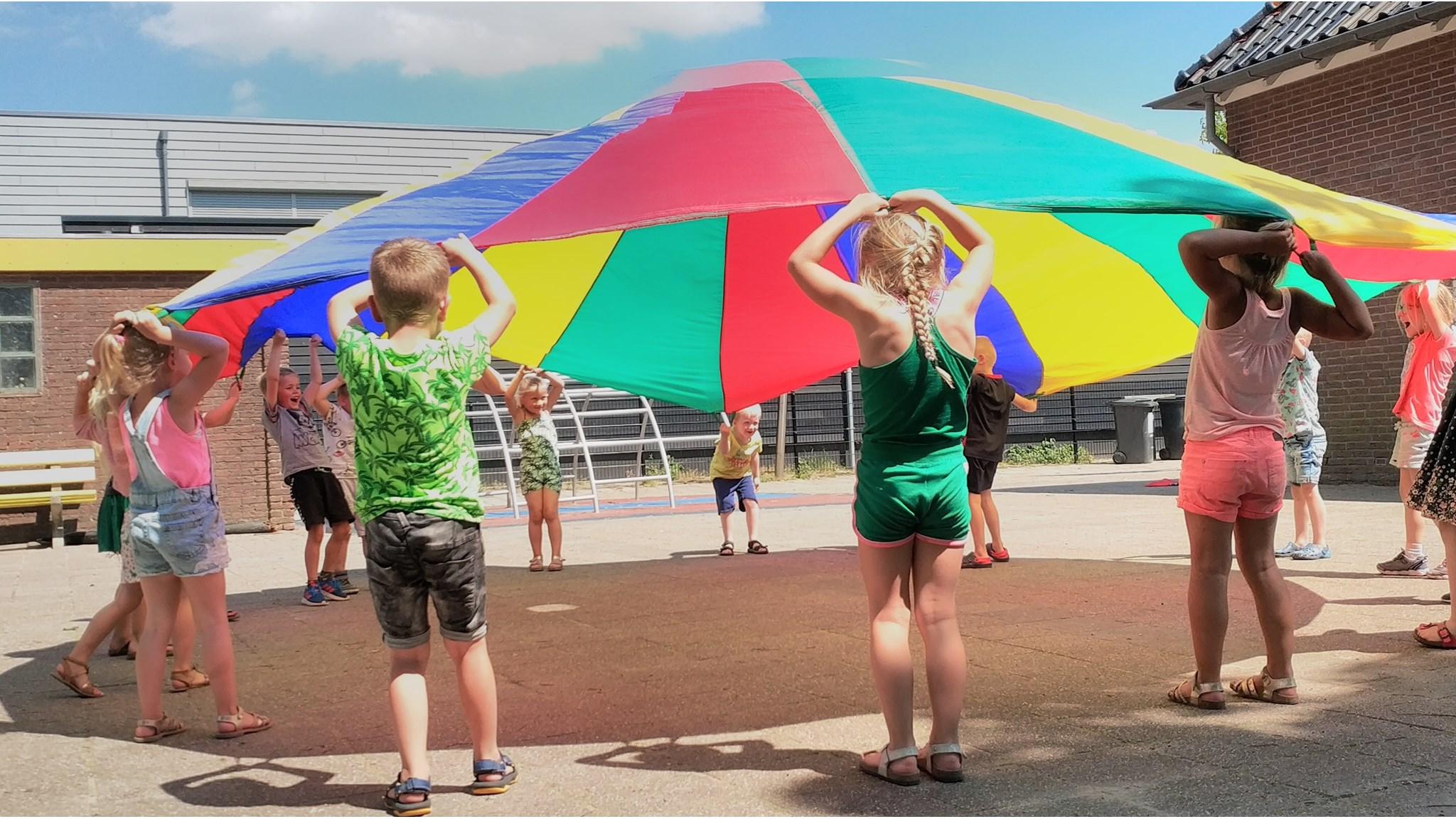 Kinderen spelen met een parachute op het schoolplein van Basisschool de Rolpaal in Blokzijl. Kinderen spelen met een parachute op het schoolplein van Basisschool de Rolpaal in Blokzijl.