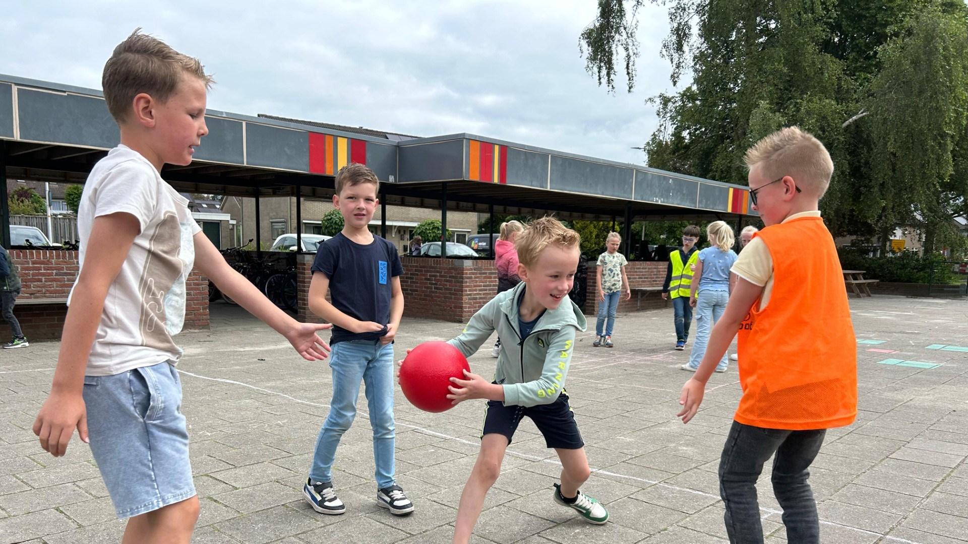 Kinderen spelen met een rode bal op het schoolplein van De Morgenster in Wierden. Kinderen spelen met een rode bal op het schoolplein van De Morgenster in Wierden.