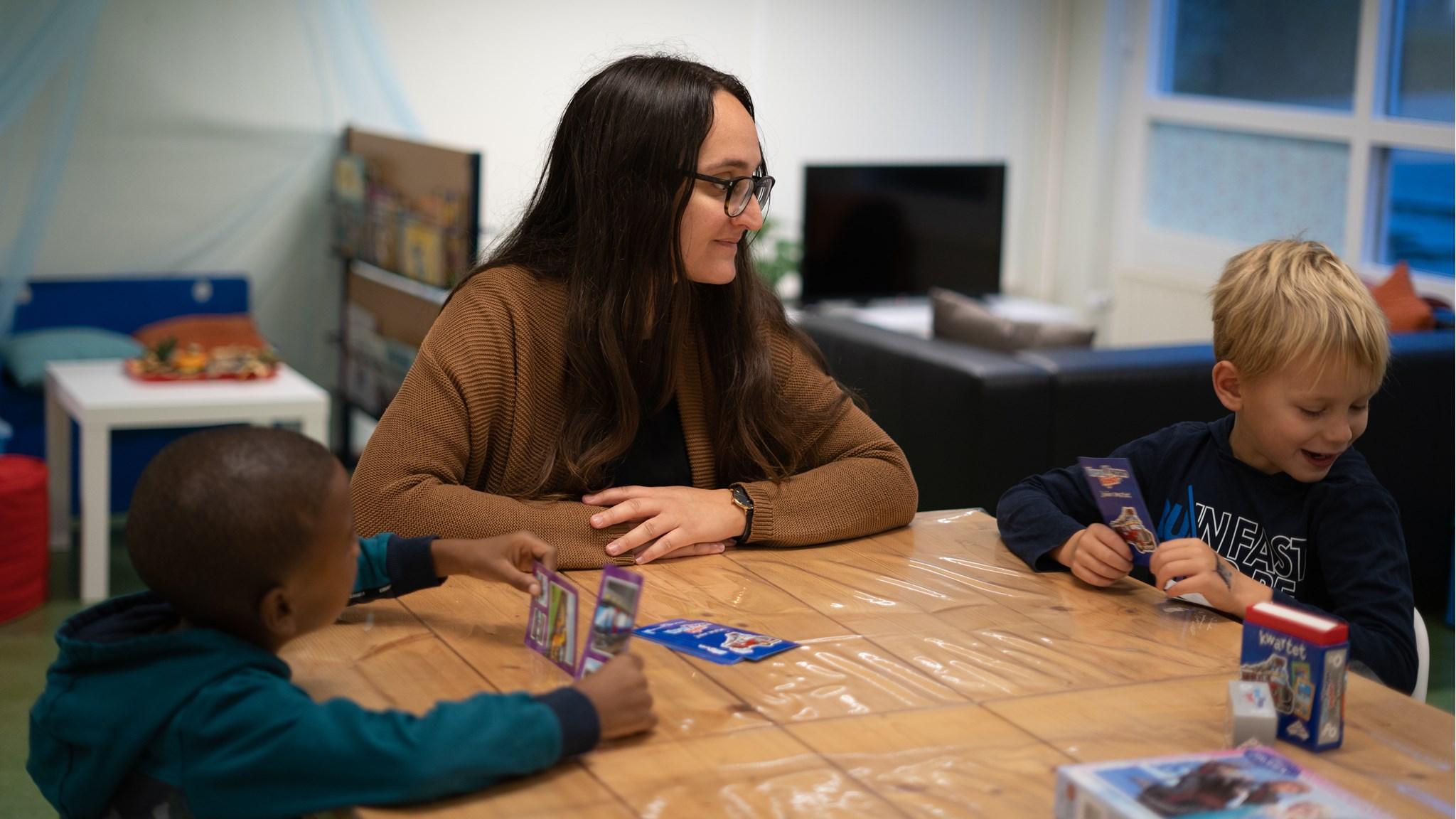 Kinderen spelen met kaarten onder begeleiding van een leerkracht bij Basisschool de Olijfboom in Almere. Kinderen spelen met kaarten onder begeleiding van een leerkracht bij Basisschool de Olijfboom in Almere.